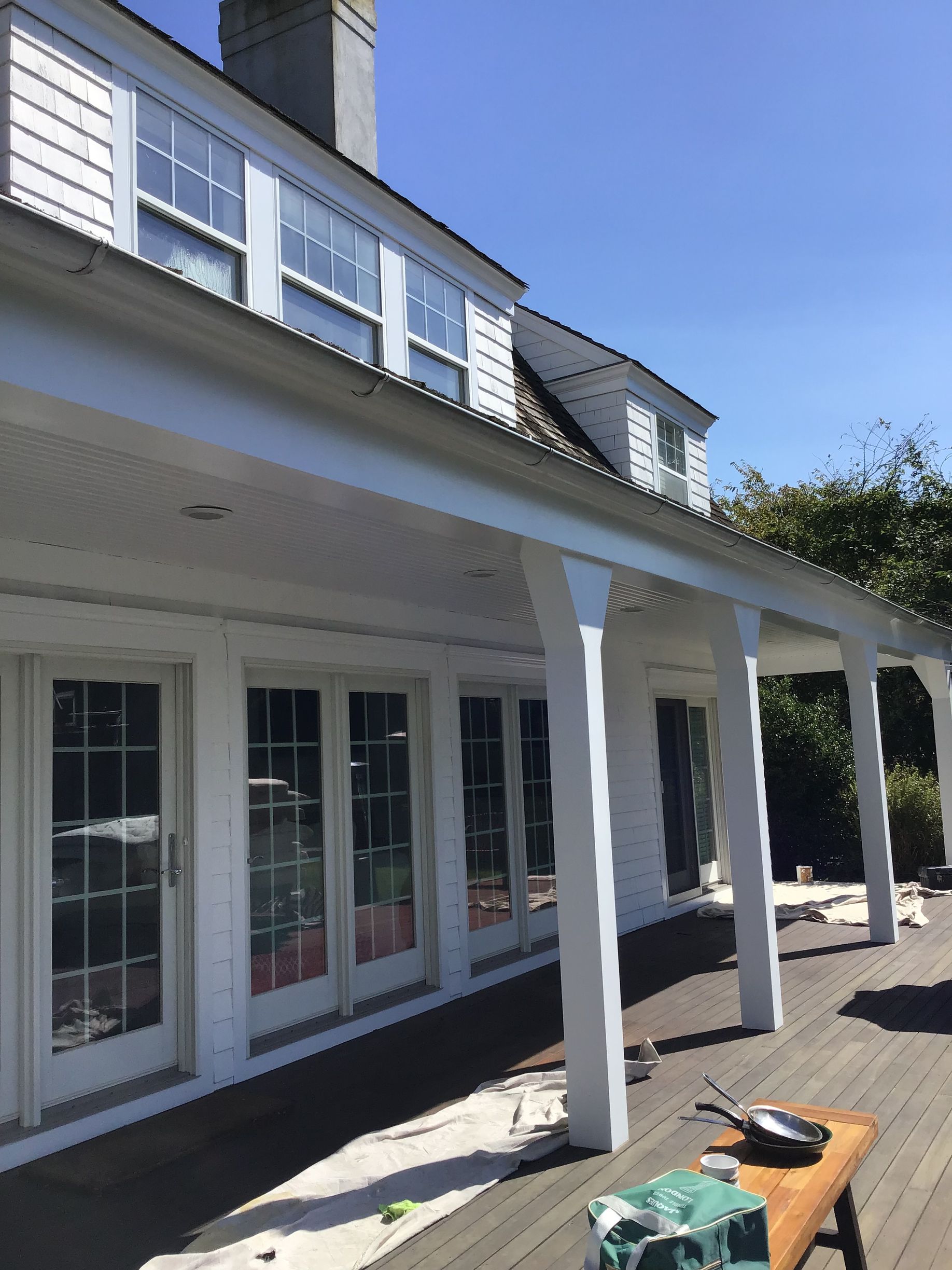 A white house with a covered porch and lots of windows