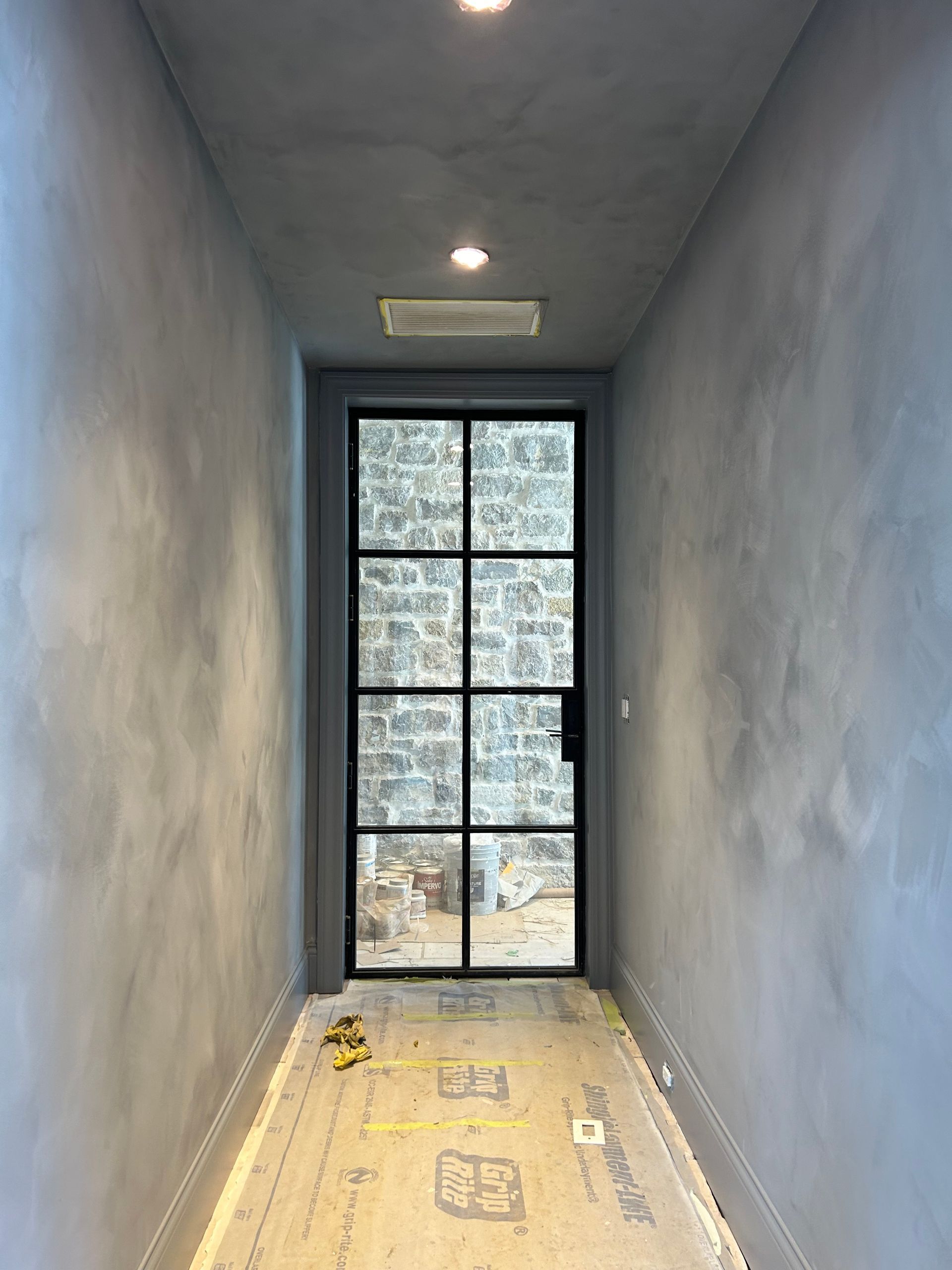 A hallway with a door and a window in it.