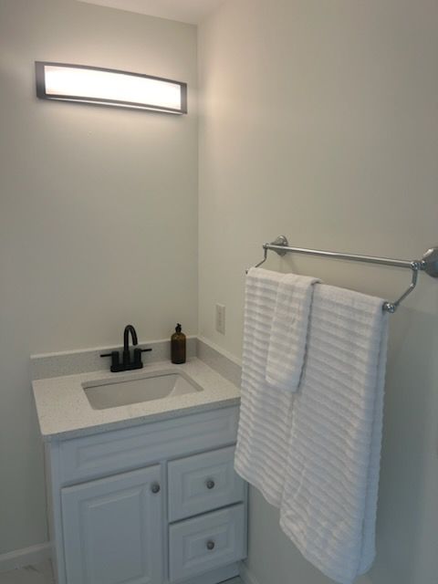 A bathroom with a sink and a towel rack