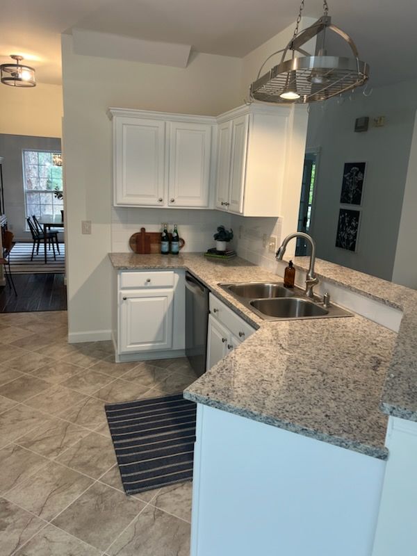 A kitchen with white cabinets and granite counter tops