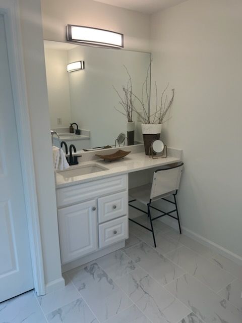 A bathroom with a vanity and a large mirror