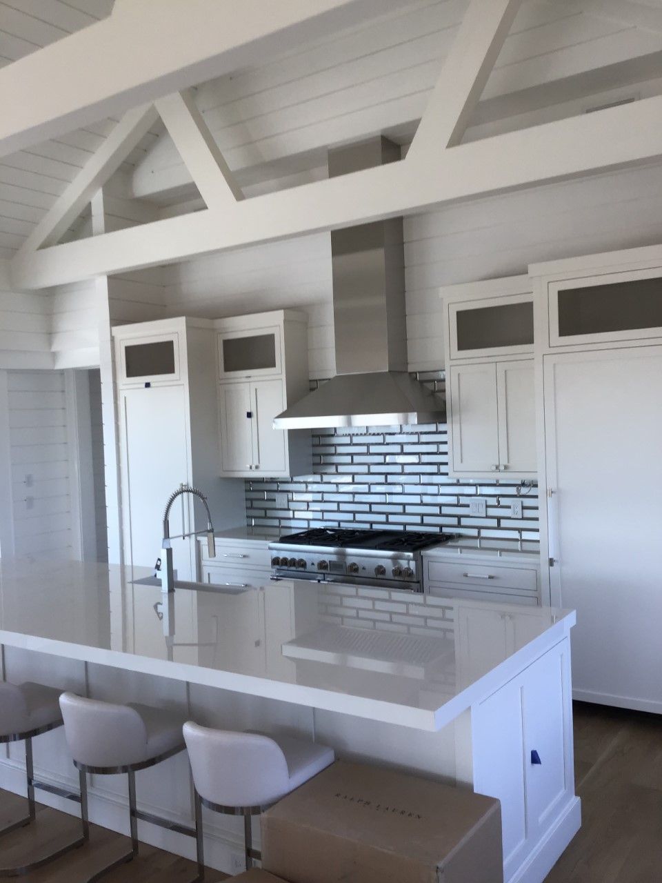 A kitchen with white cabinets and a stove top oven