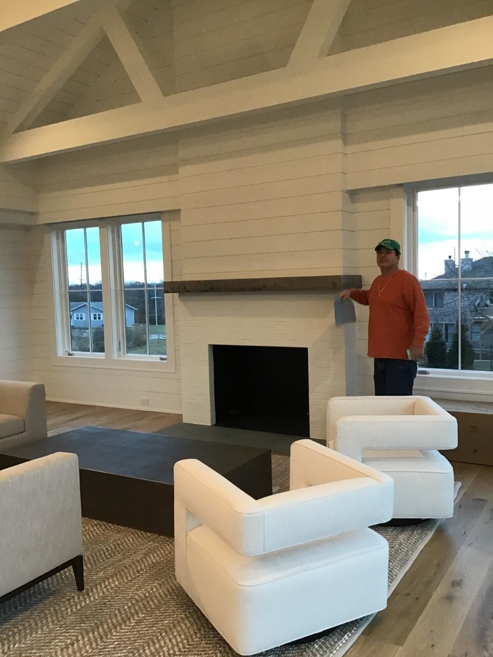 A man is standing next to a fireplace in a living room
