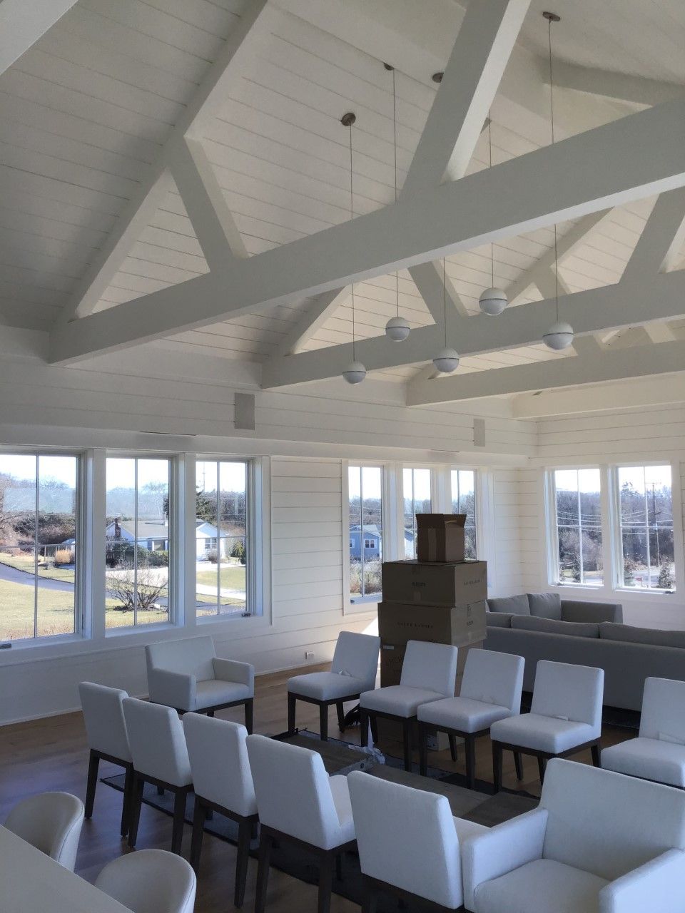 A large room with lots of white furniture and a vaulted ceiling