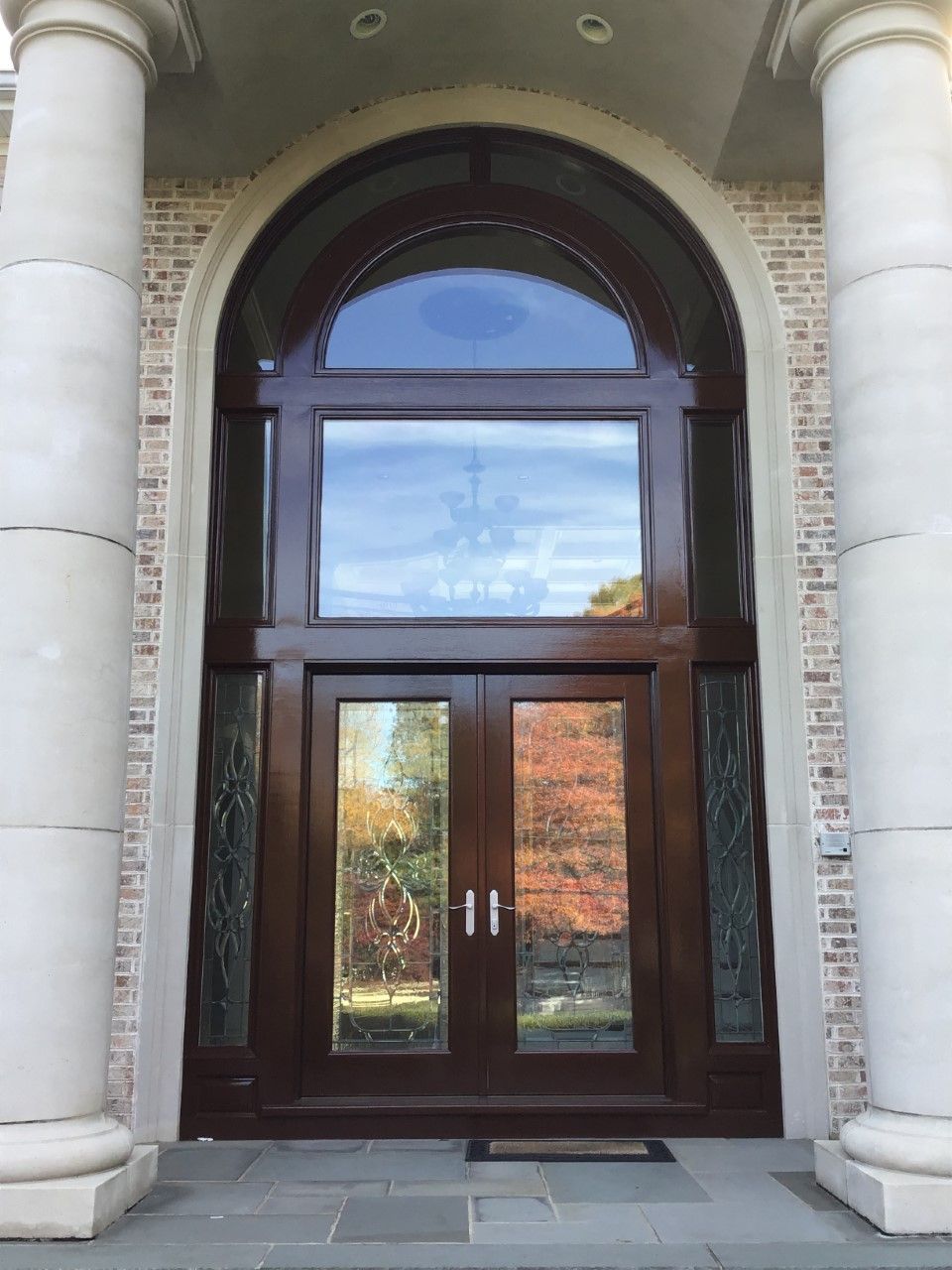 The front door of a house with columns and arched windows