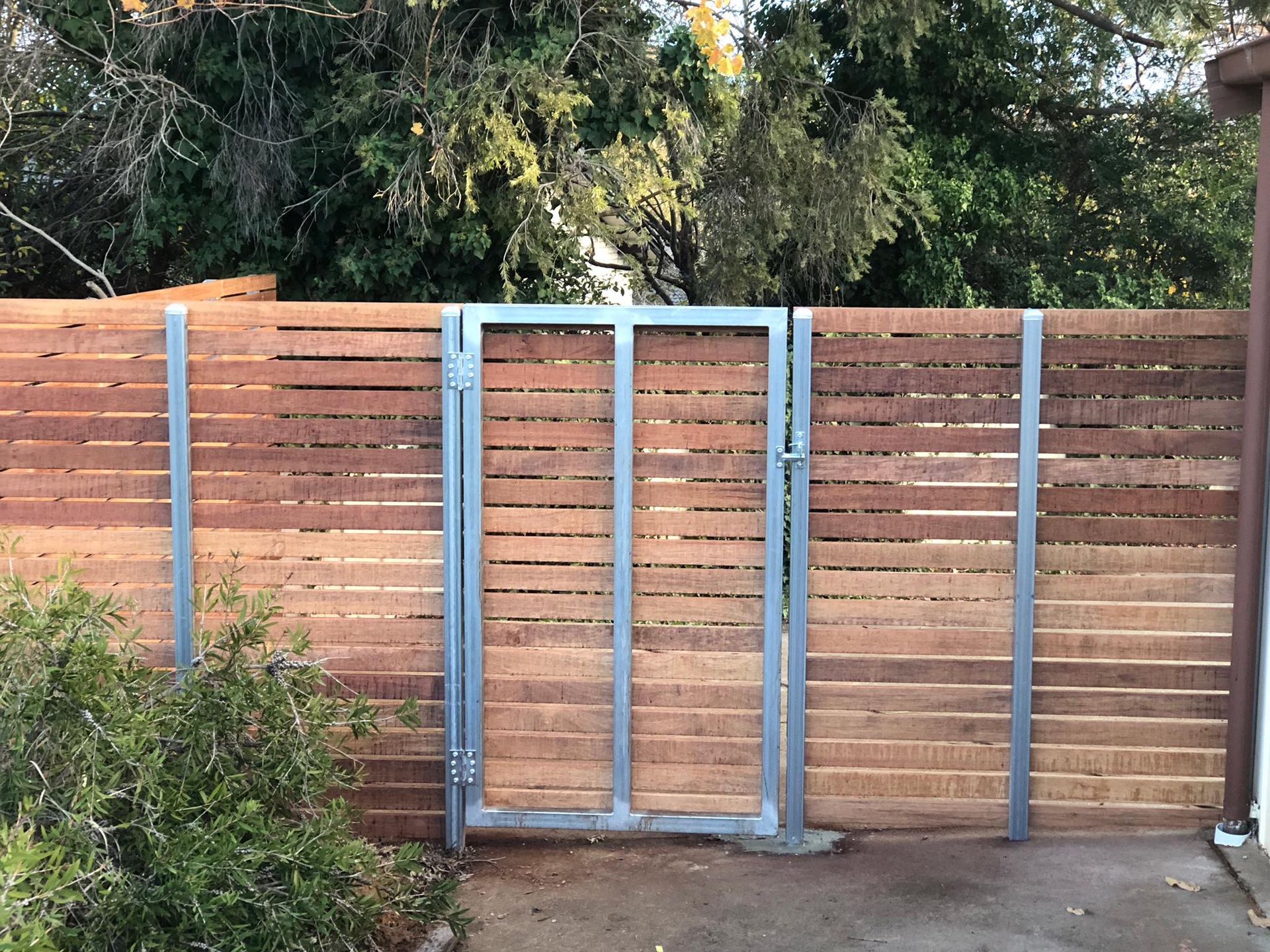 A wooden fence with a metal gate attached to it.