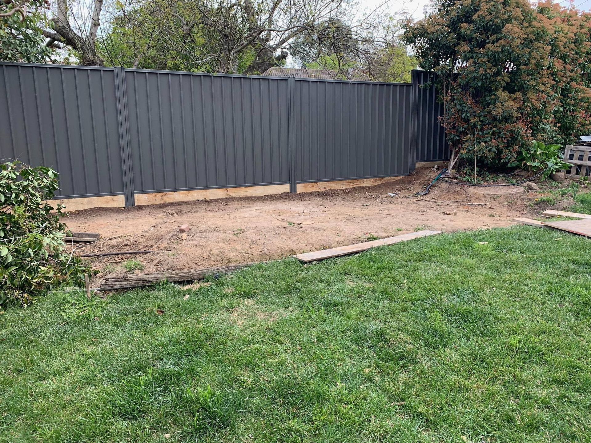 A backyard with a Colorbond steel fence and a lot of grass.