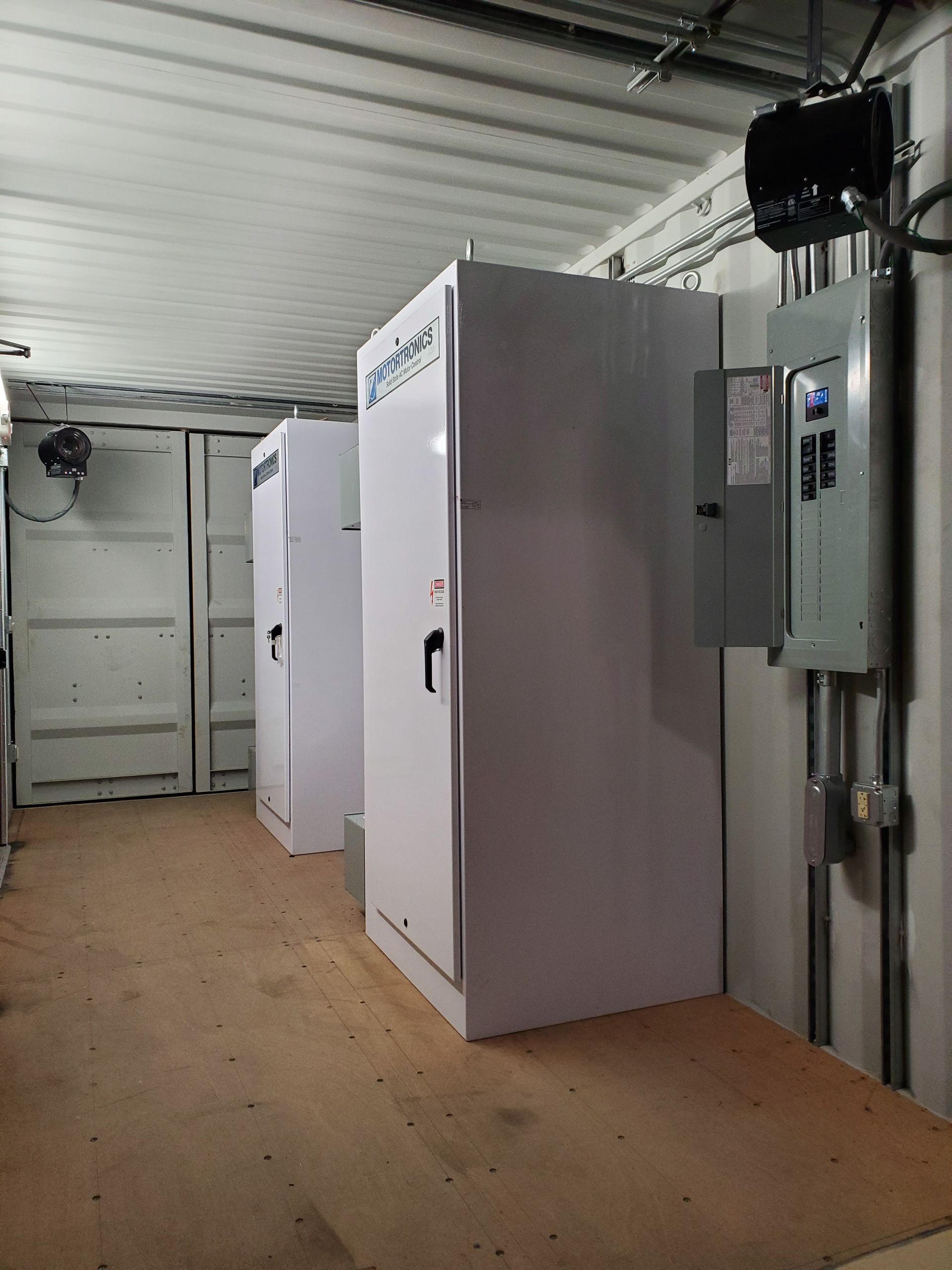 A man is holding a bunch of wires in a warehouse.