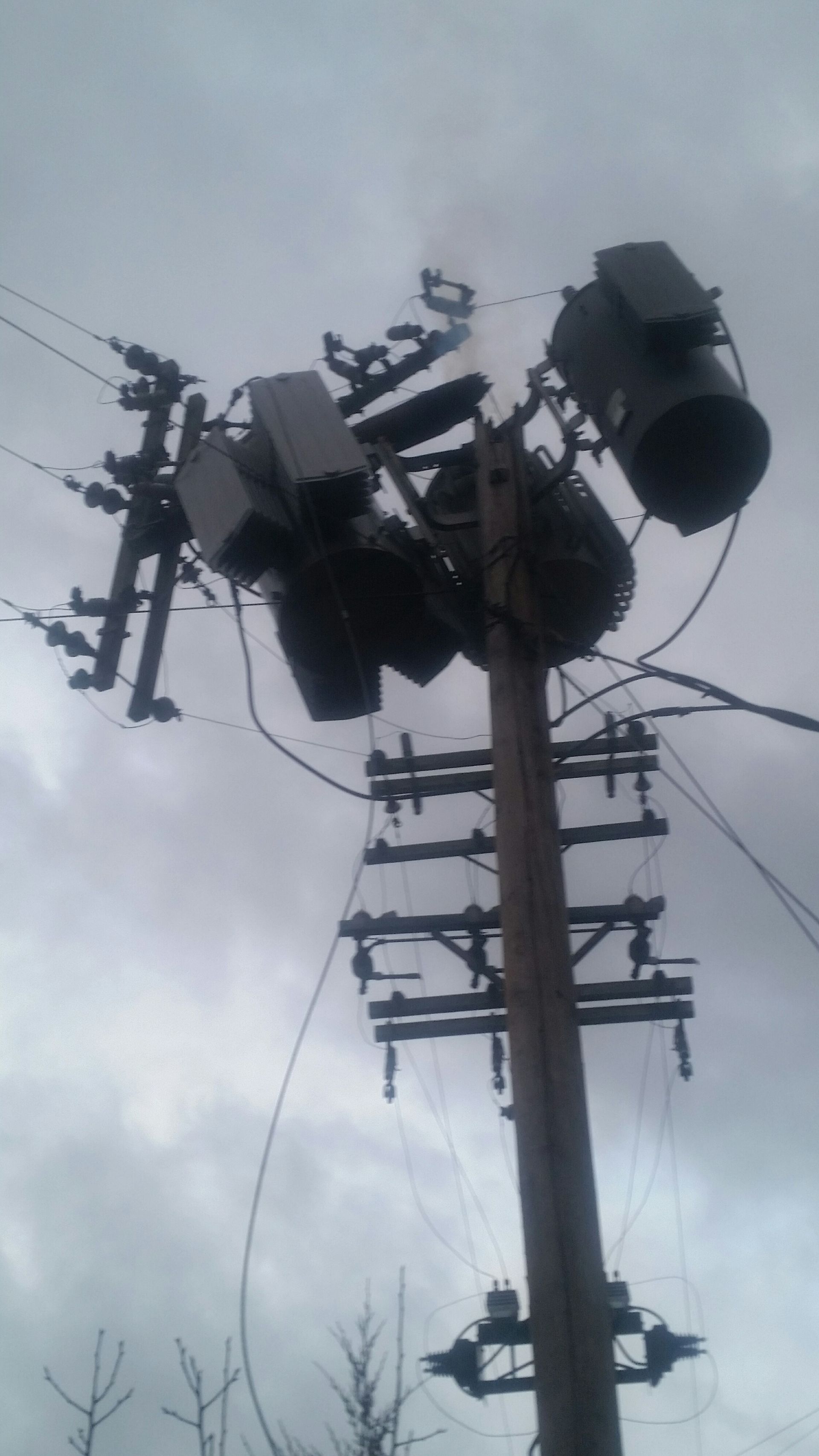 An electrician is writing on a clipboard next to a hard hat