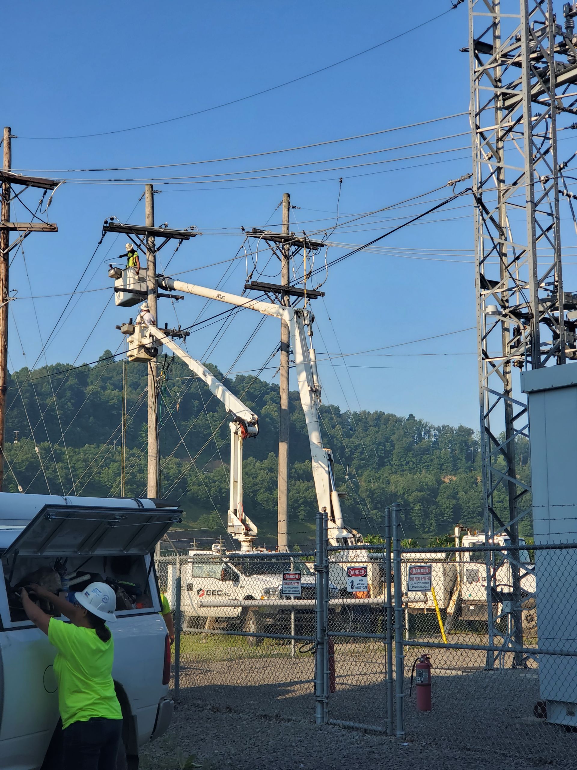 A man in a hard hat is working on an electrical box.