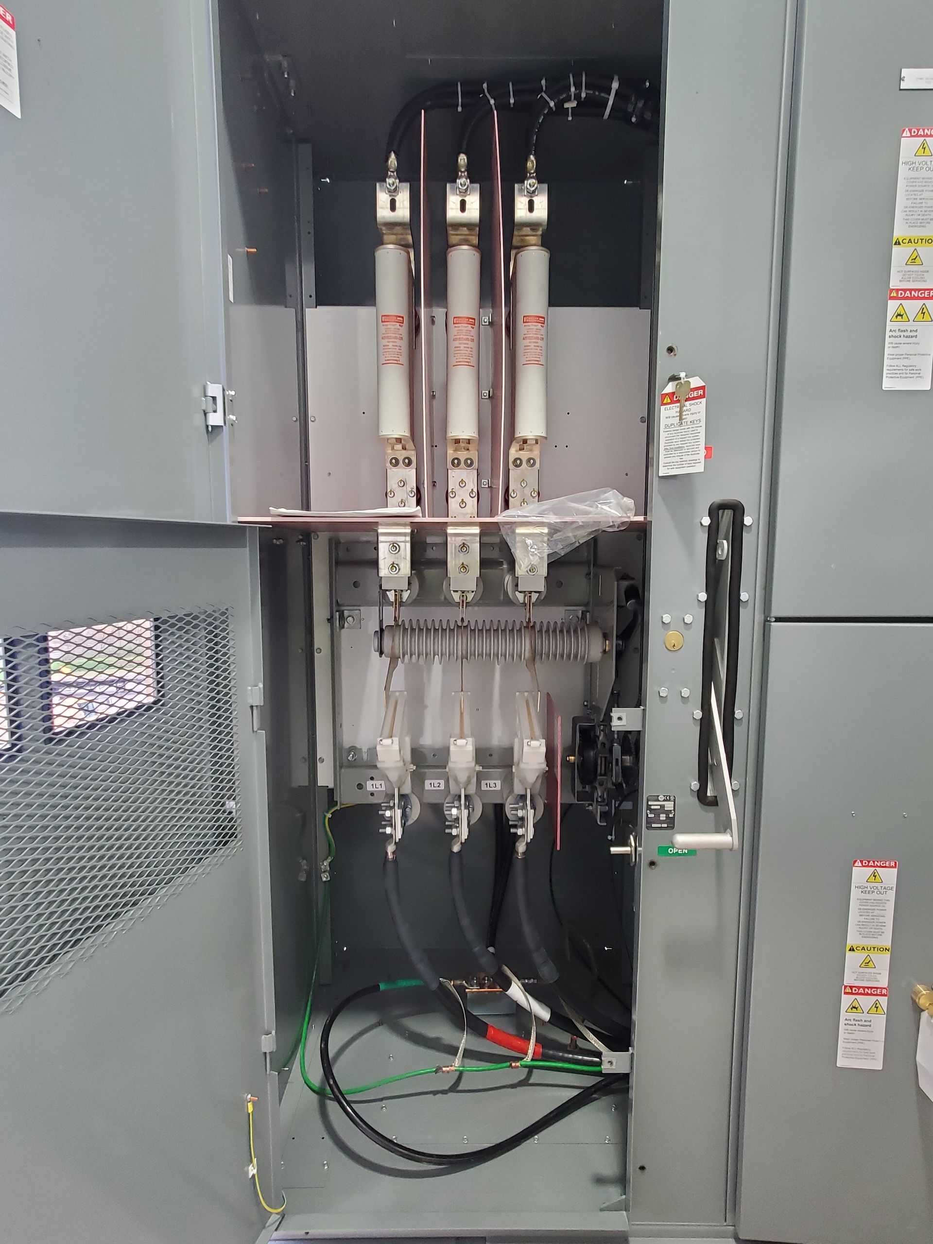 Two men are working on an electrical box.