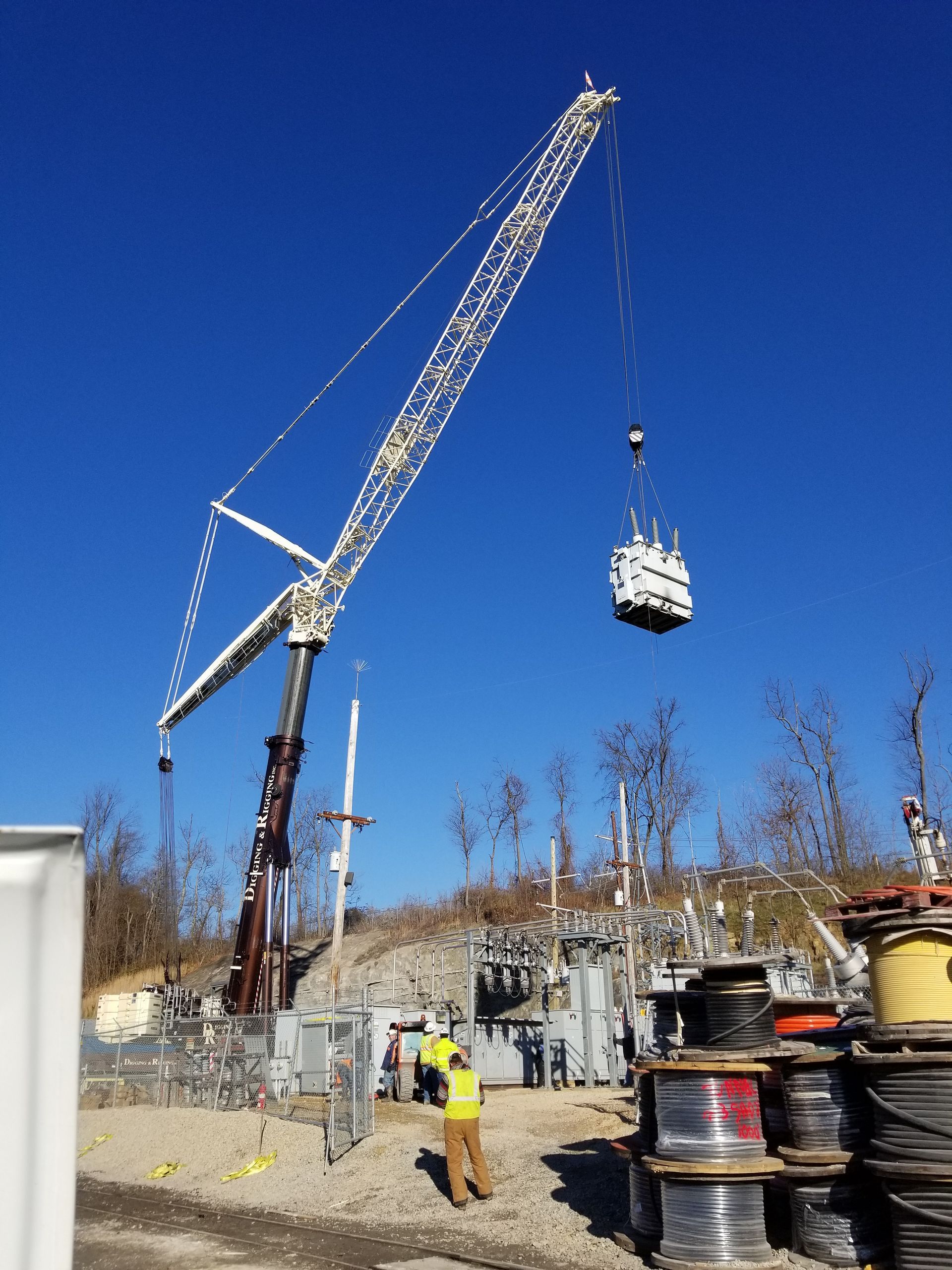 An electrician is working on a wall with a screwdriver.