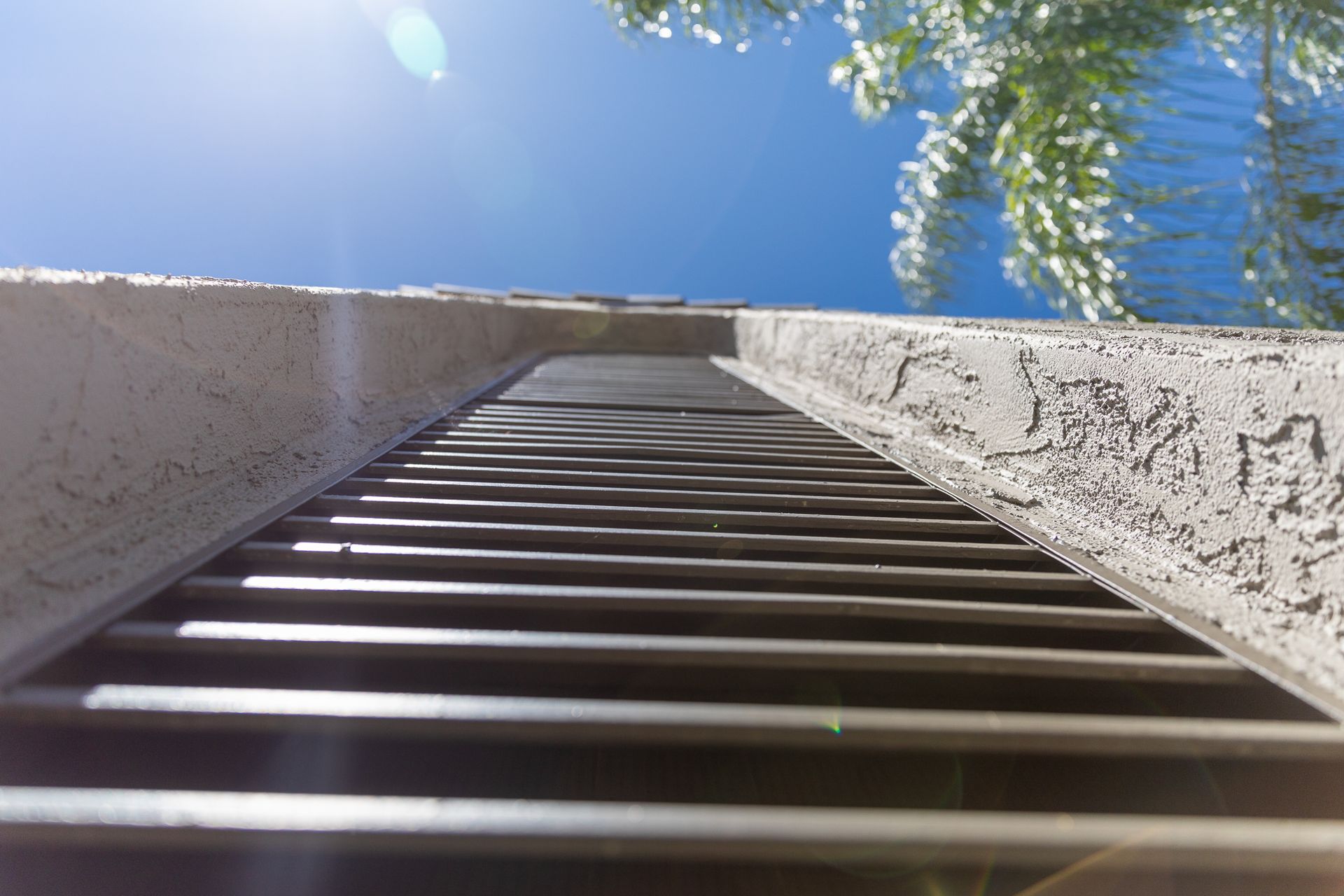looking up at a metal staircase with a blue sky in the background