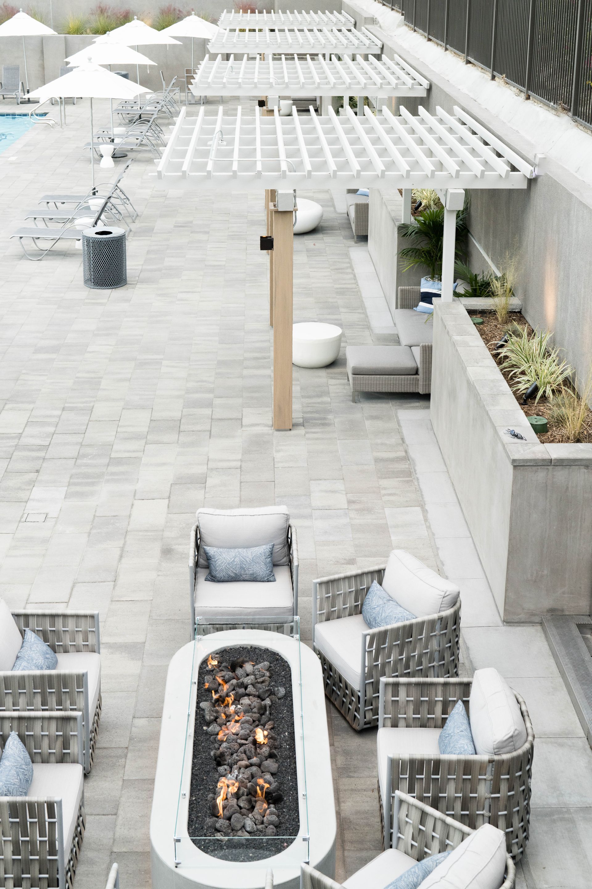 a patio area with a fire pit and chairs