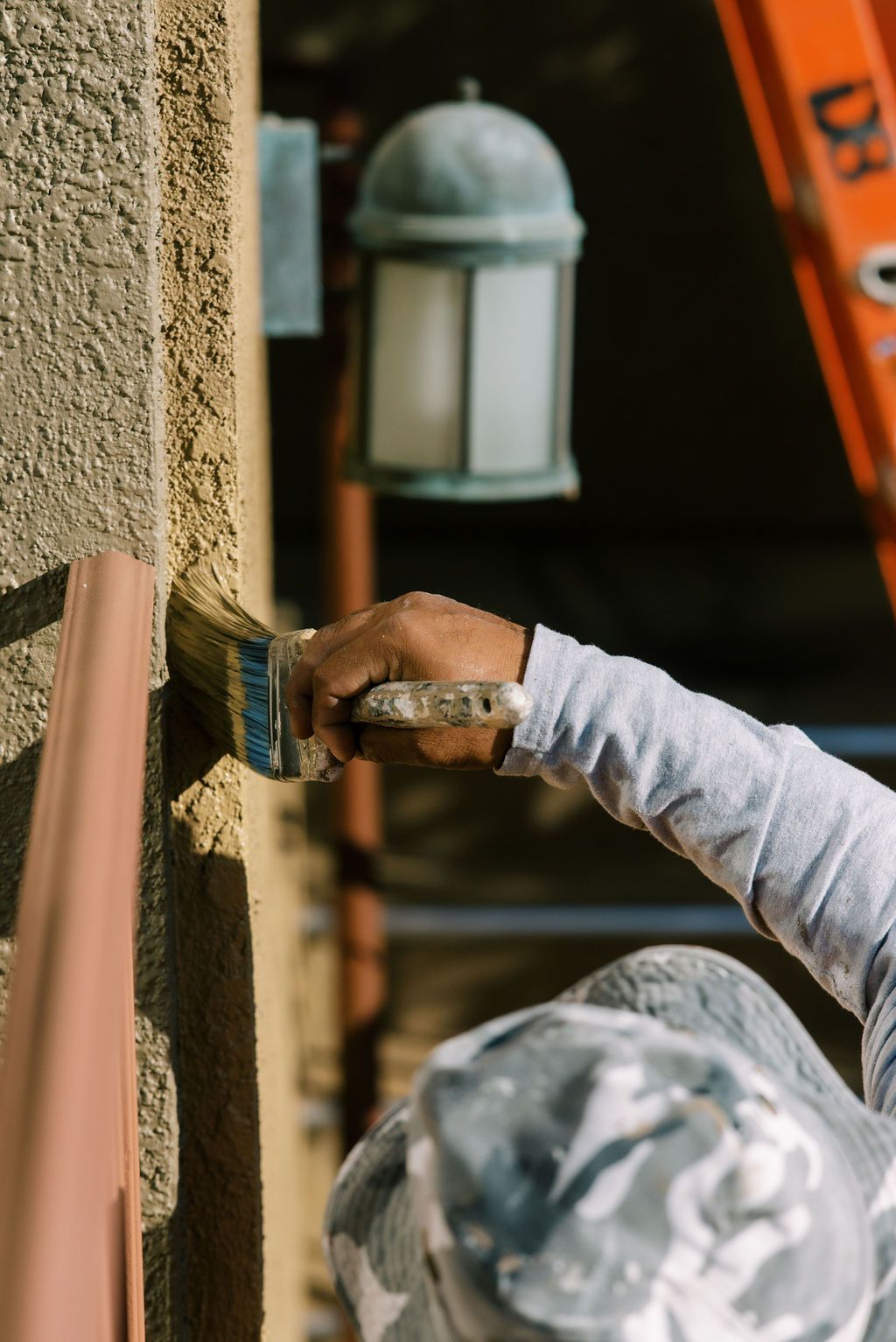 A person is painting a wall with a brush.