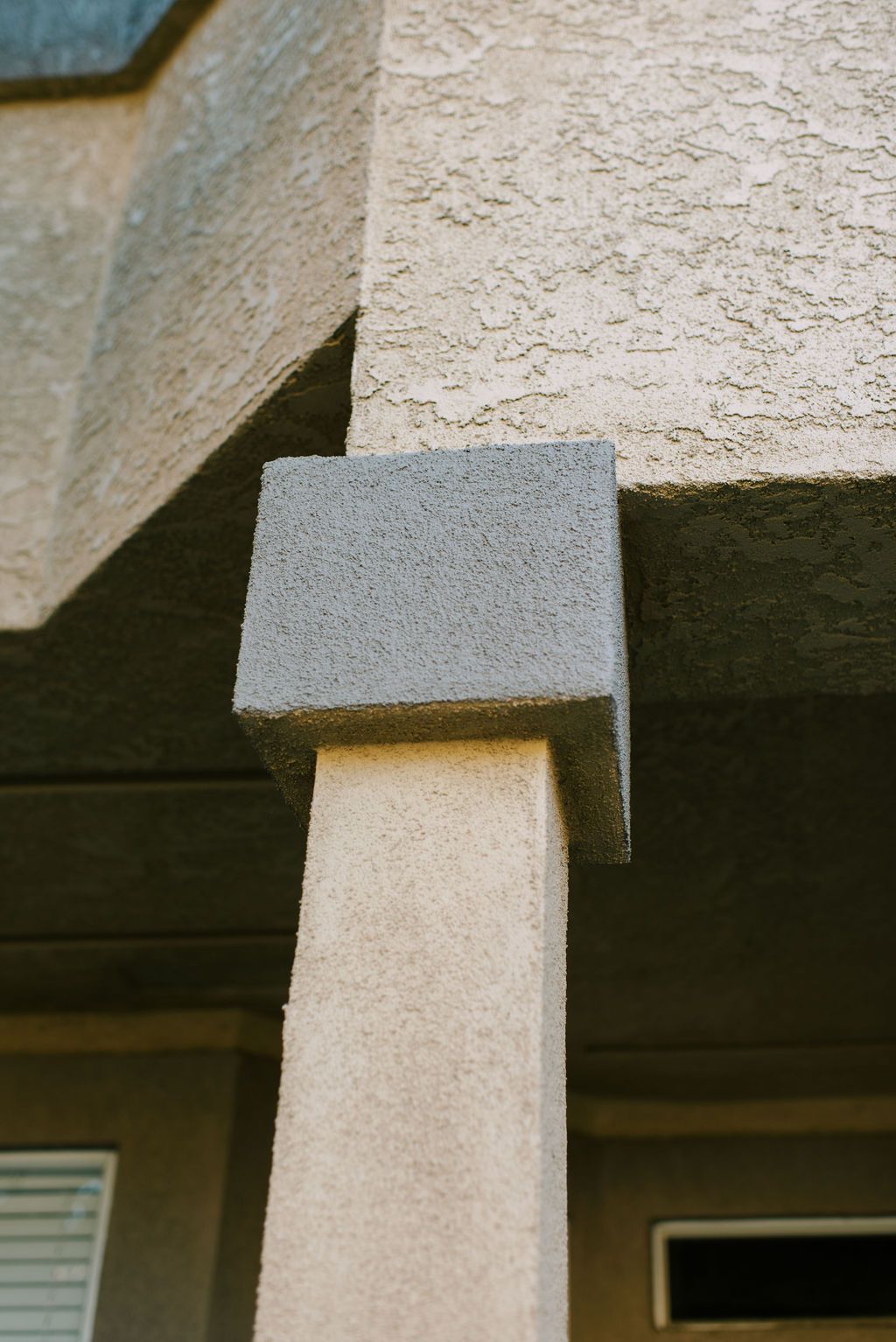 the corner of a building with a gray pillar