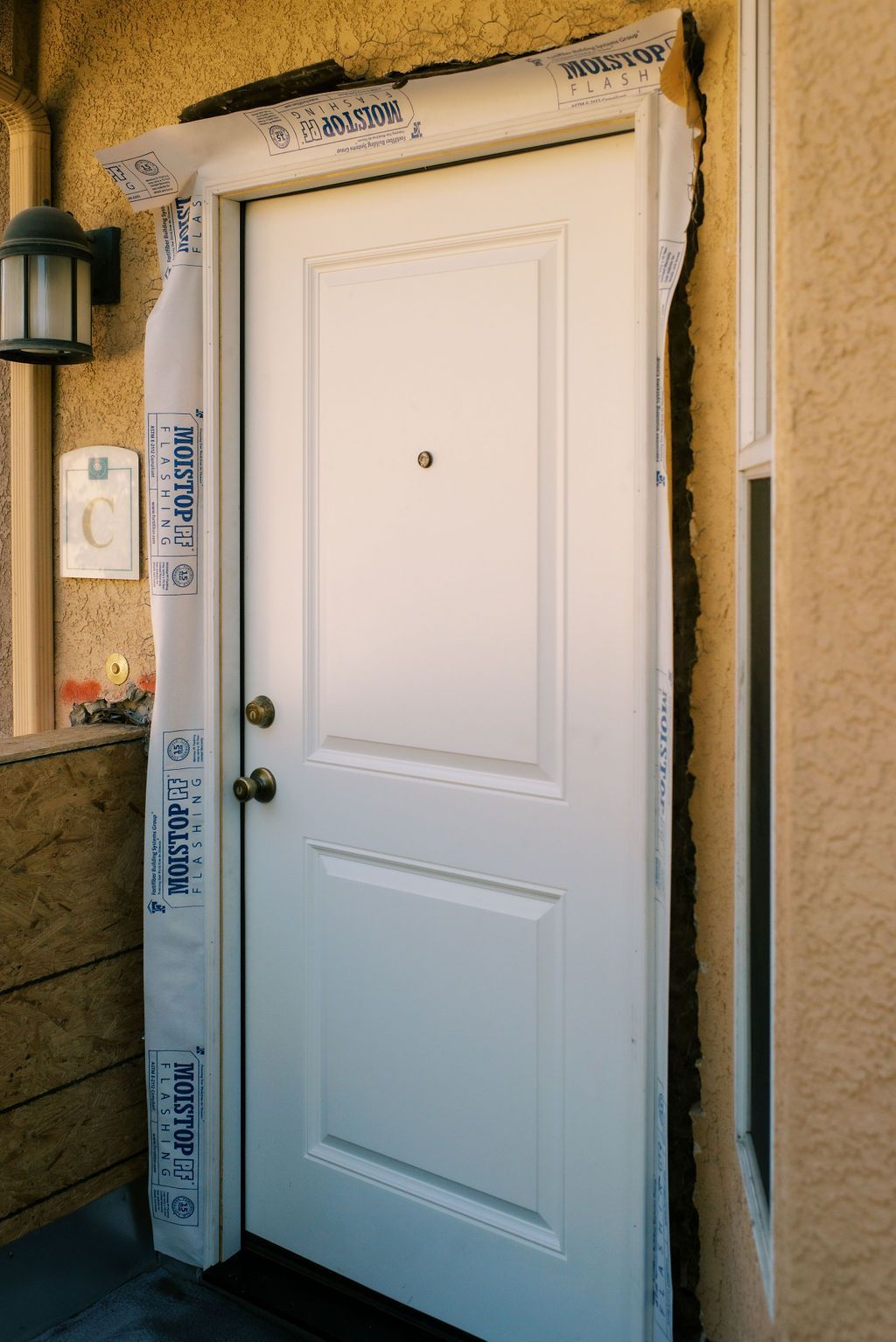 a white door is wrapped in moisture barrier paper