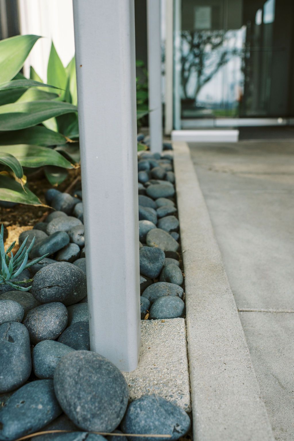 a white pole is surrounded by rocks and plants