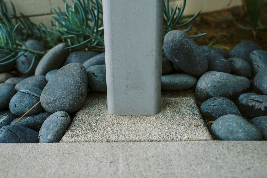 a metal post is surrounded by rocks and sand