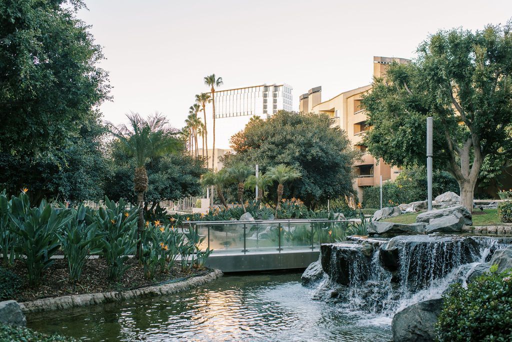 a waterfall in a park with a building in the background
