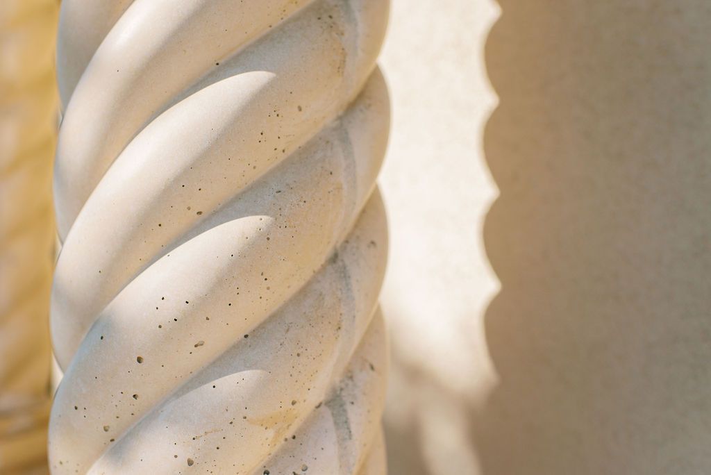 a close up of a twisted white pillar