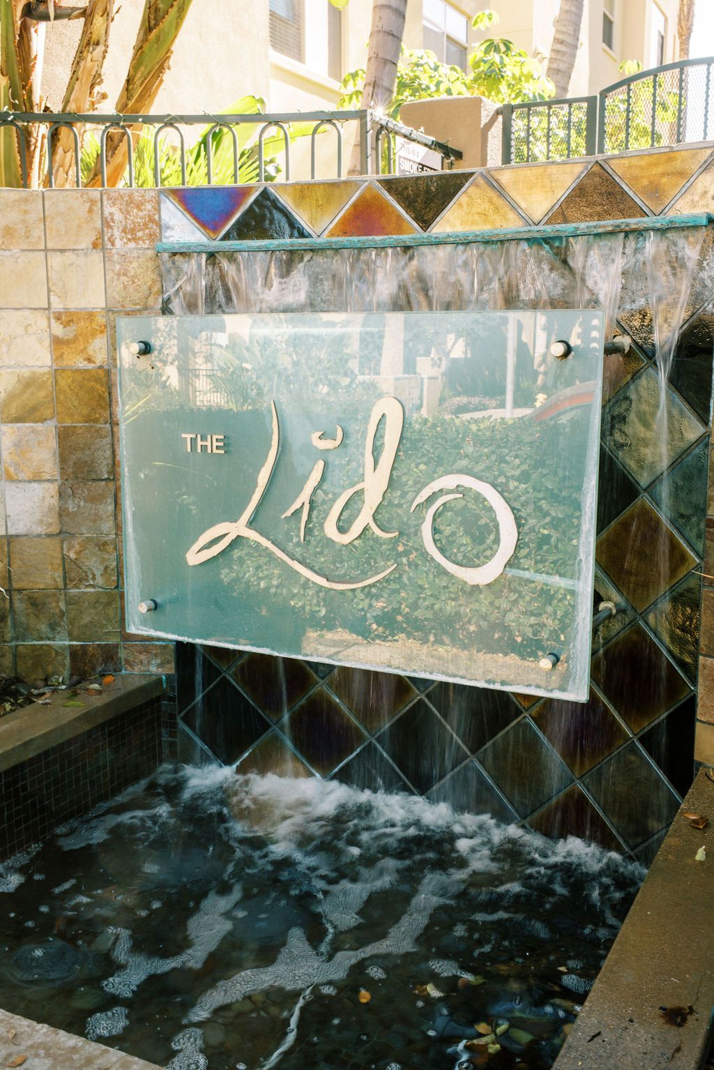 a waterfall behind a sign that says the lido