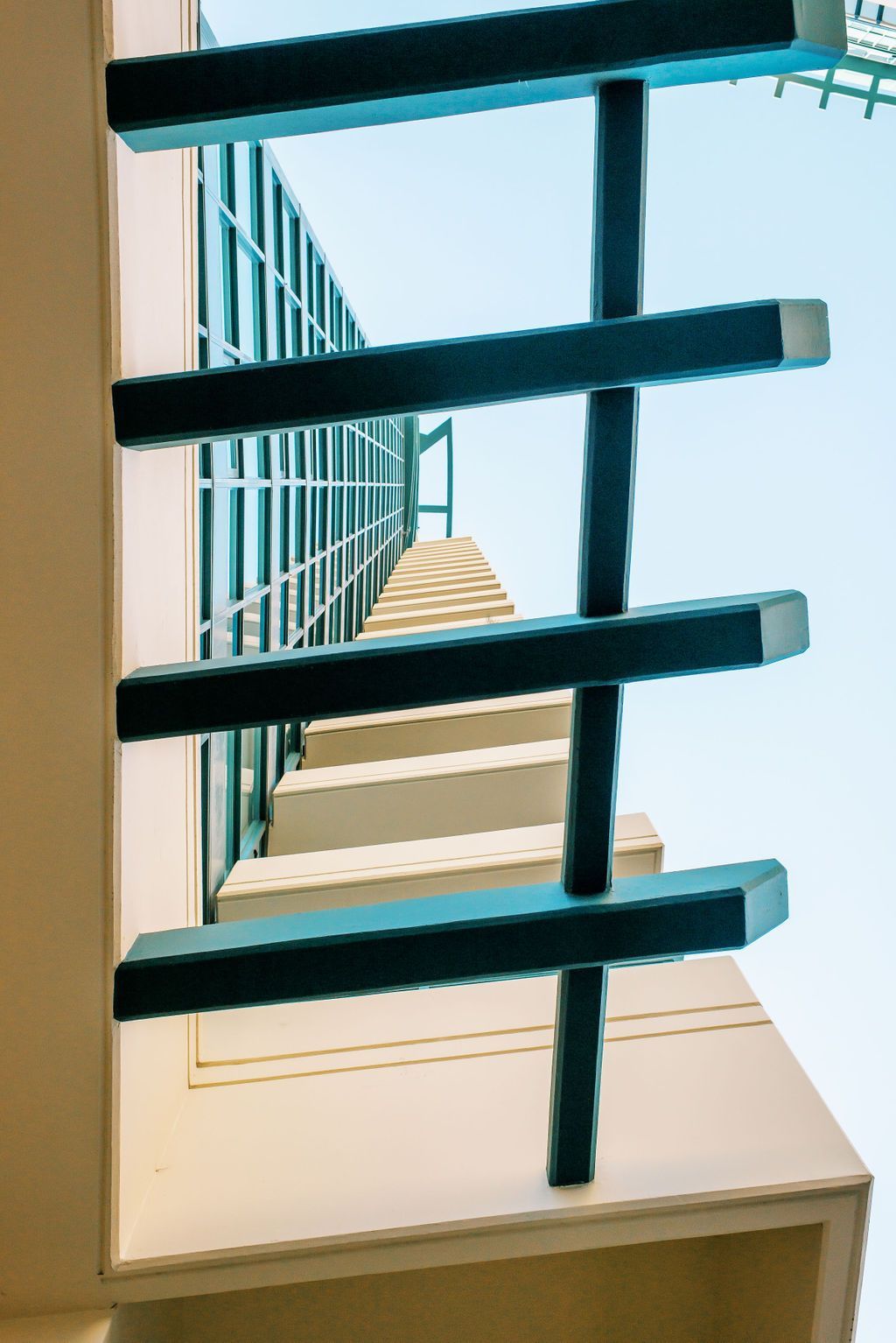looking up at a building with a blue railing