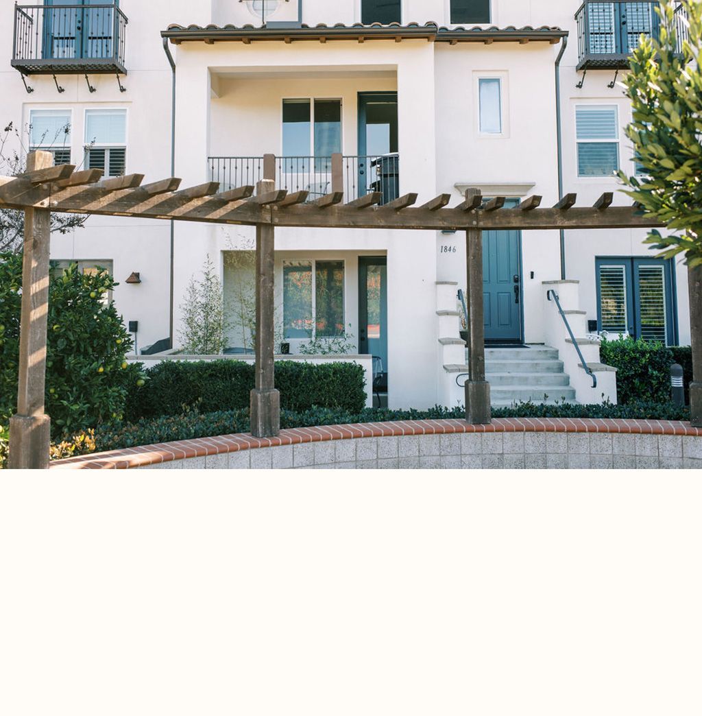 A white house with a pergola in front of it