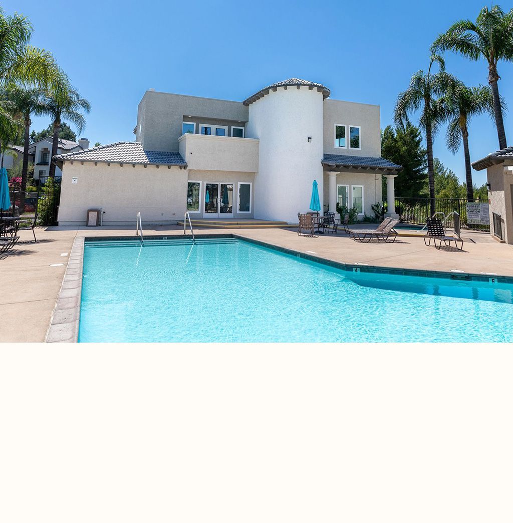 A large white house with a large swimming pool in front of it