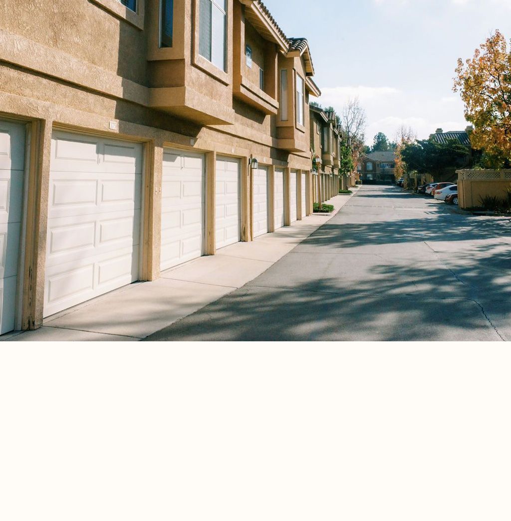A row of apartment buildings with white garage doors