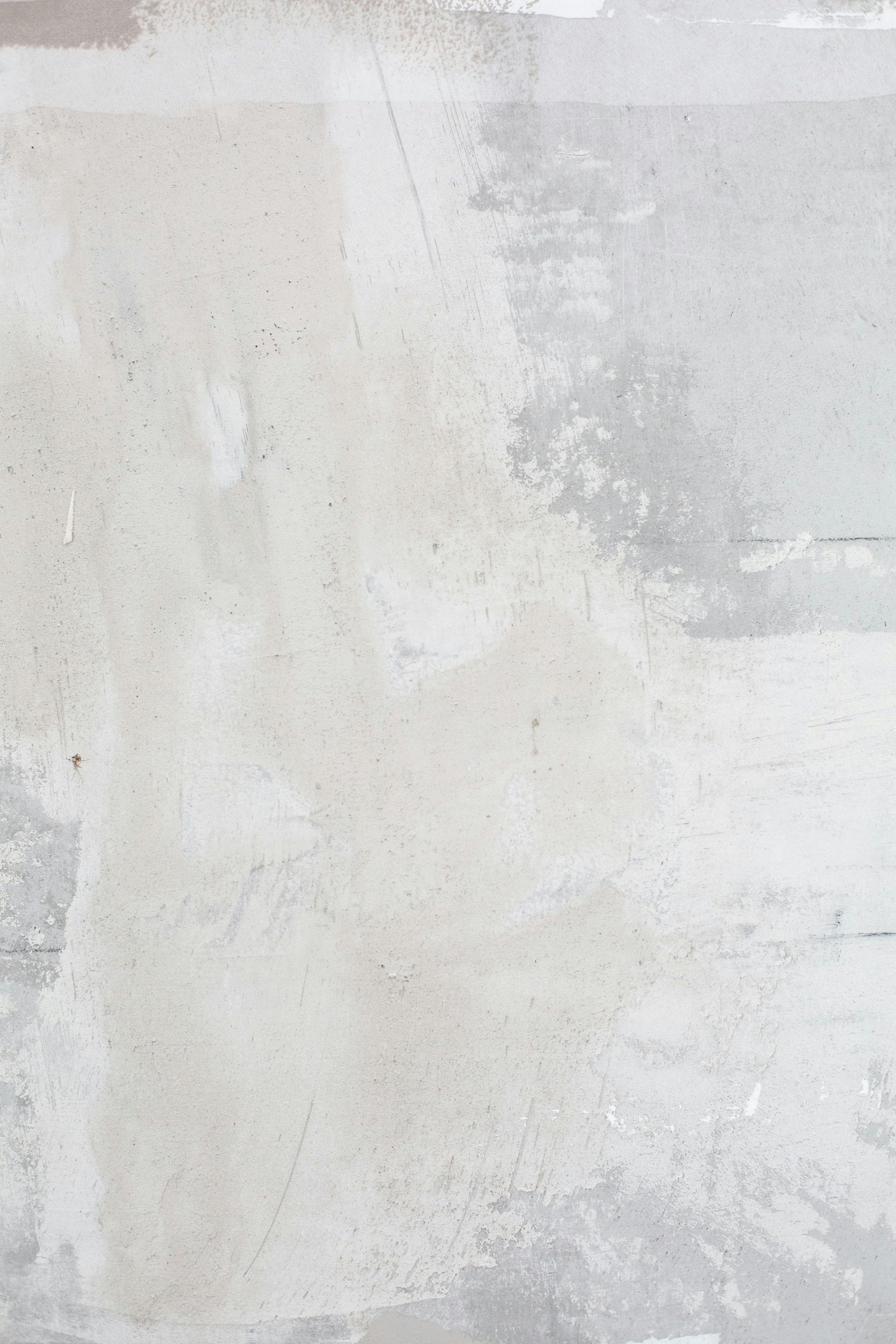 Textured light gray concrete wall with patches of lighter and darker shades.