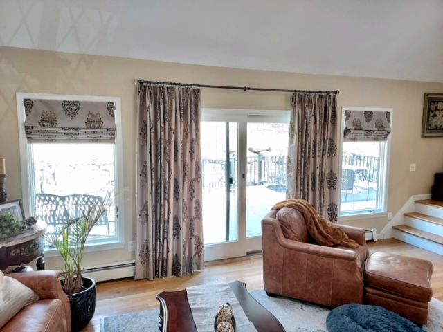 Living room with patterned curtains, leather armchair, and patio door.