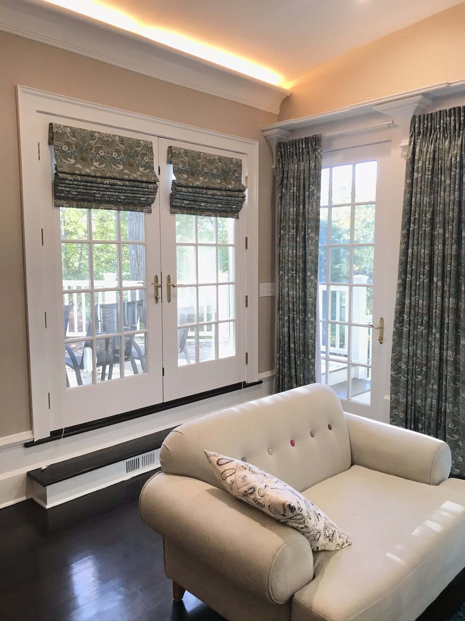 A living room with a couch , chair and sliding glass doors.