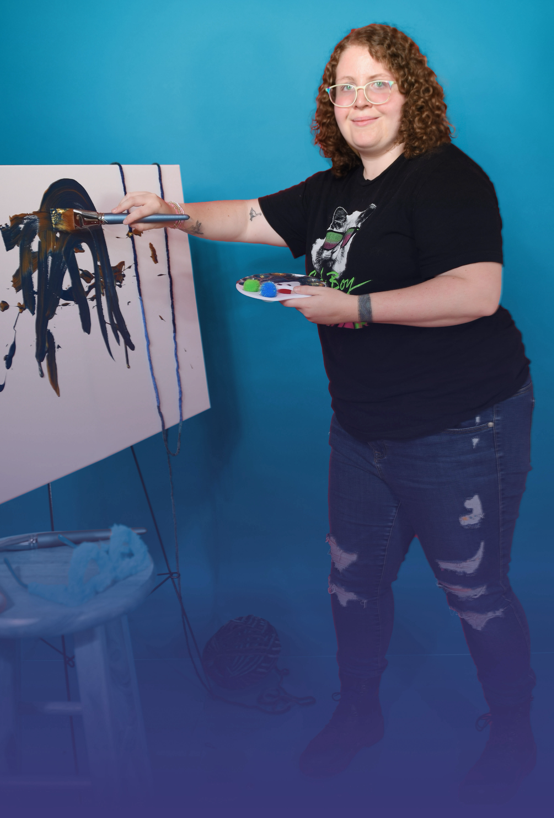 A woman is smiling while standing in the woods.