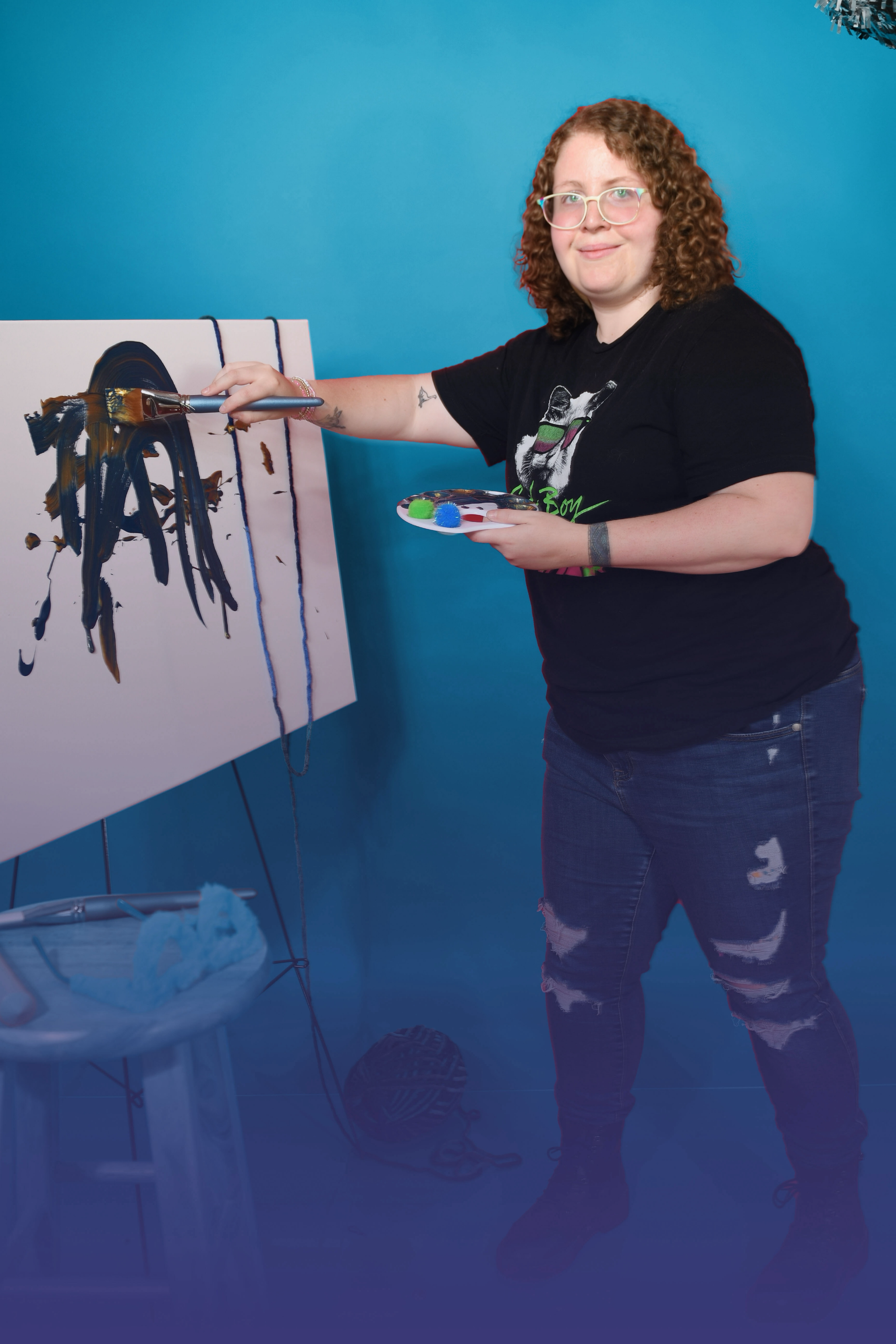 A woman is smiling while standing in the woods.