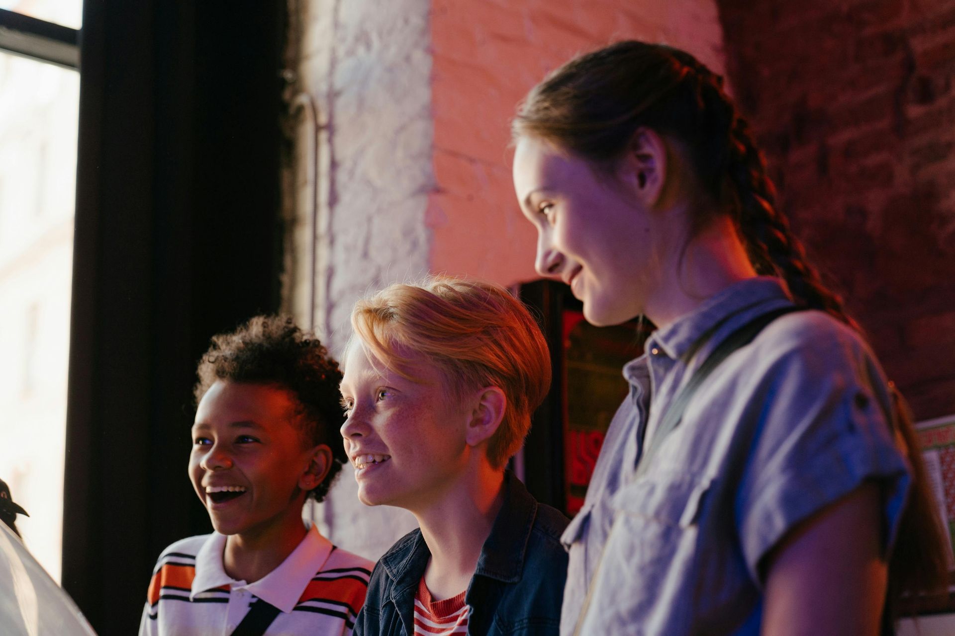 Three children looking at their game with excited expressions.
