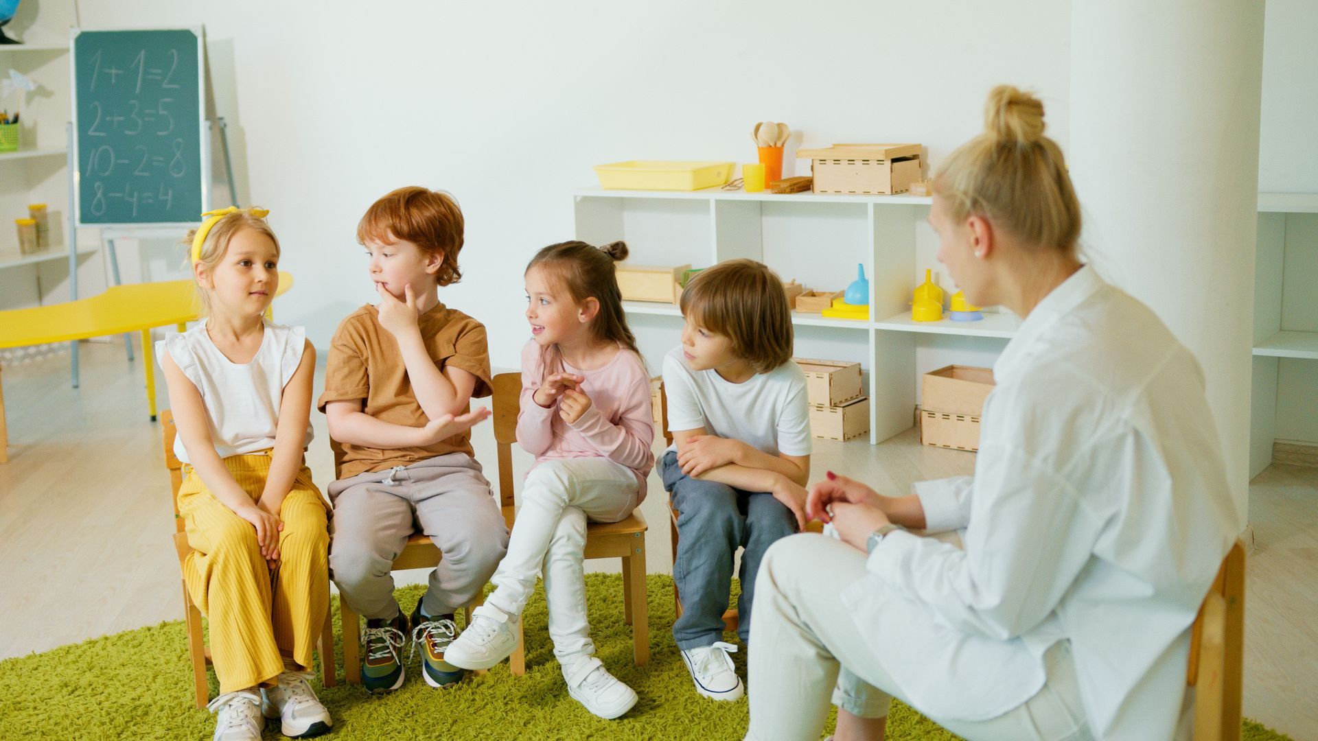 Youth sitting in a circle outside laughing.