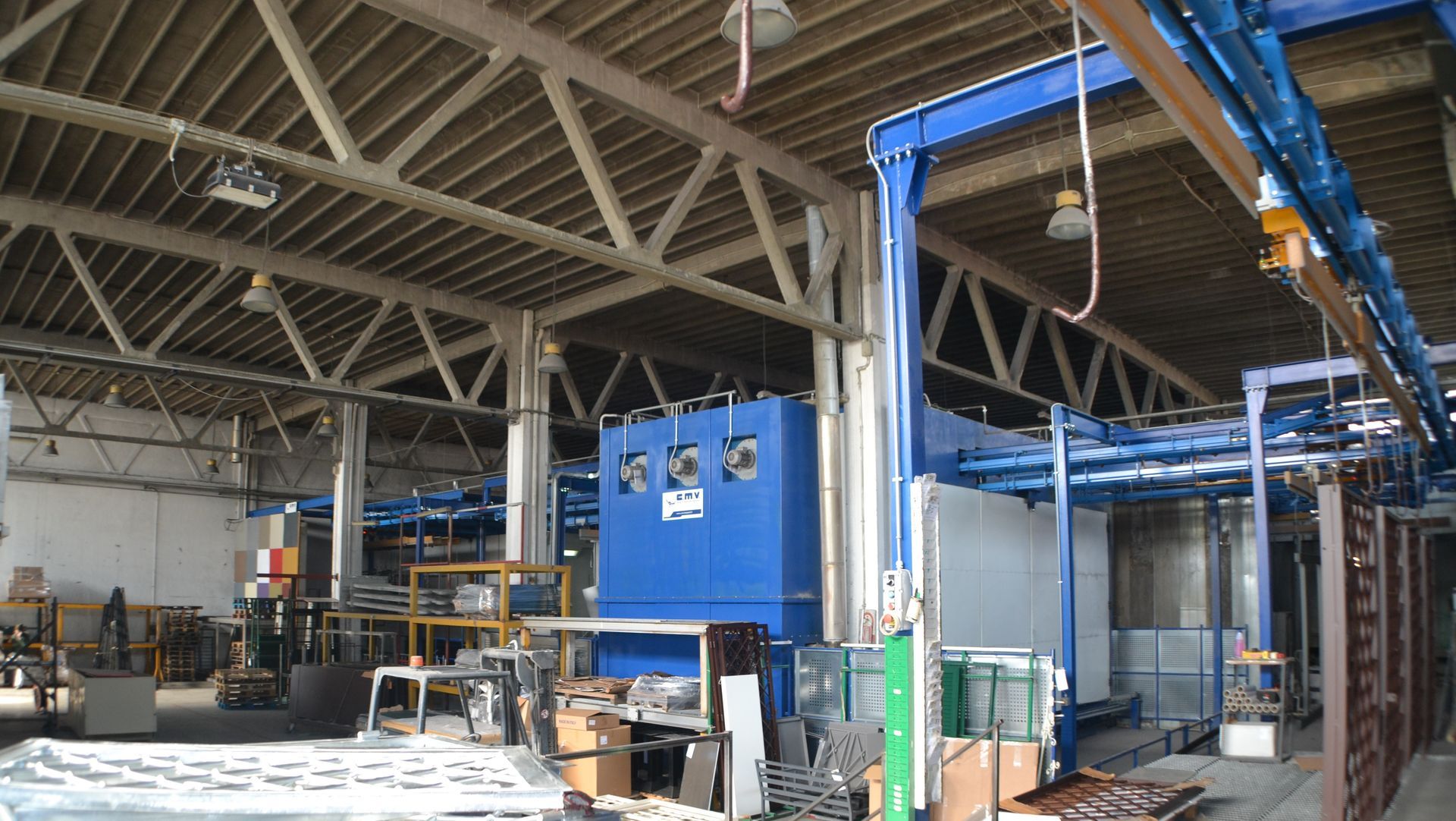 Un grande magazzino con una macchina blu al centro