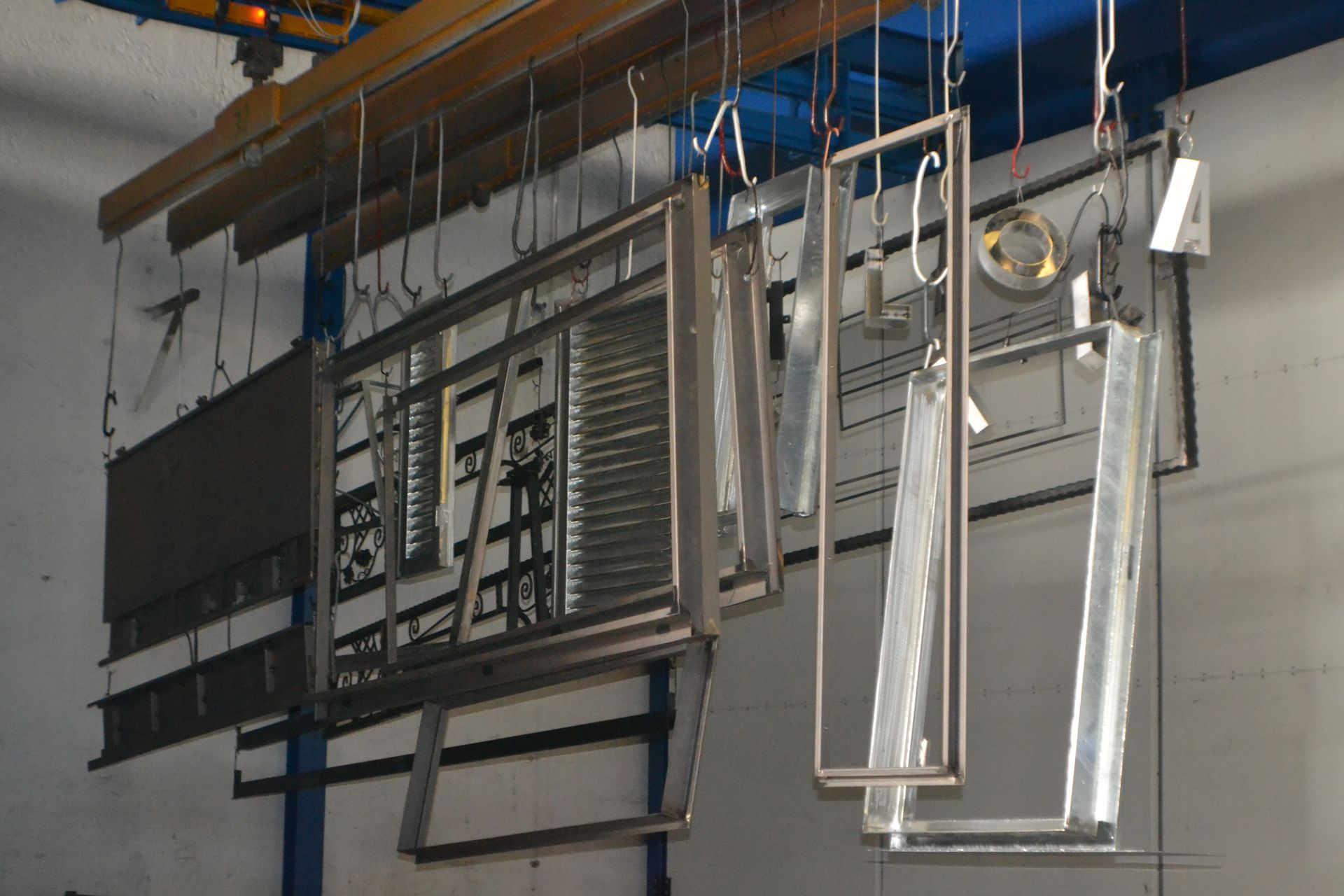 Un mucchio di telai metallici sono appesi al soffitto di una fabbrica.