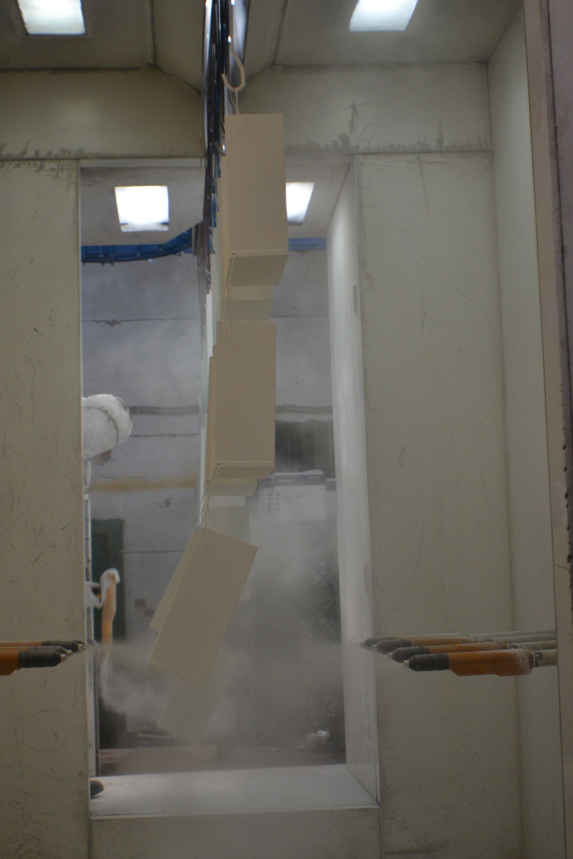 In una stanza di una fabbrica si sta dipingendo una scala.