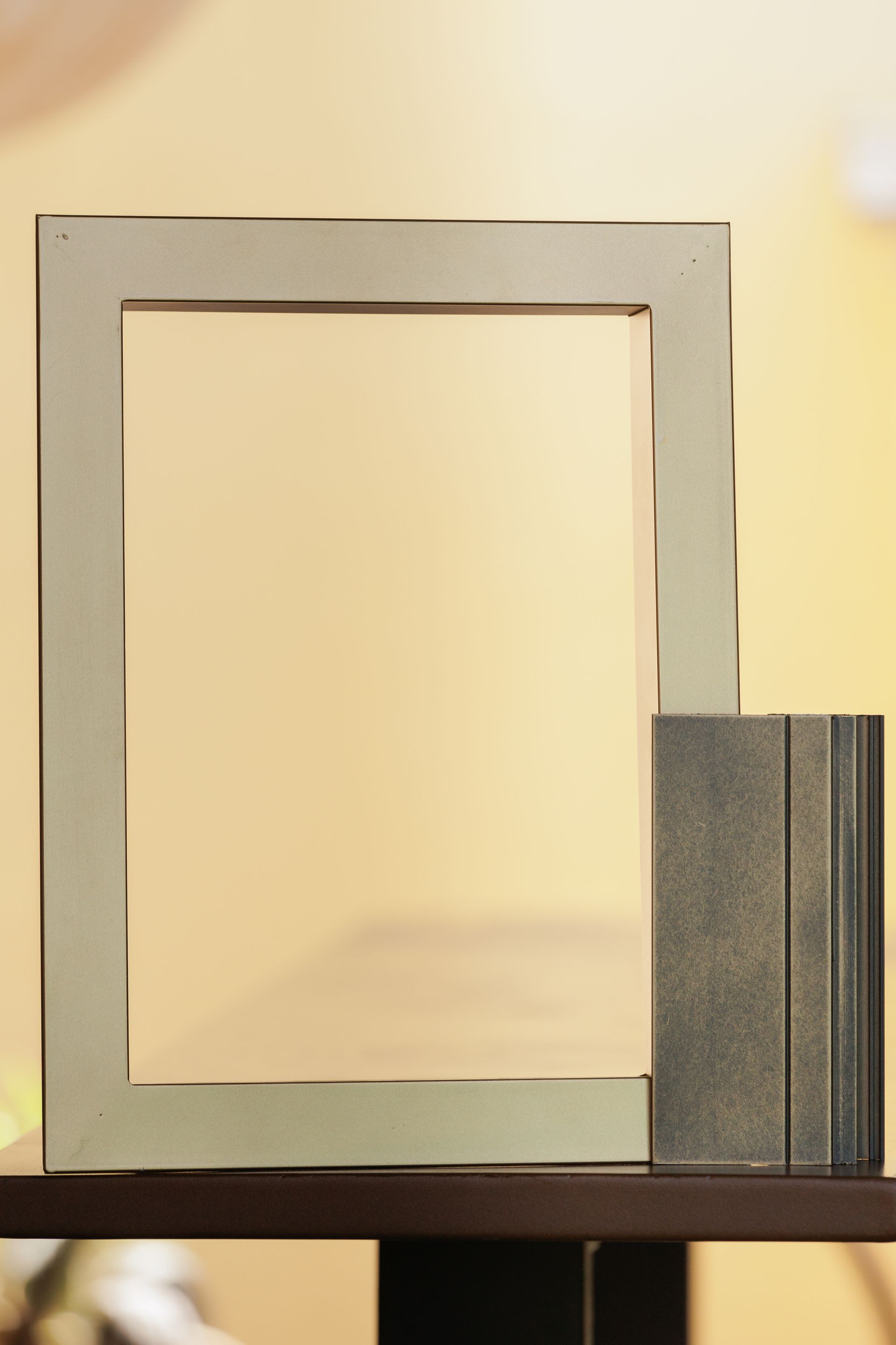 Una cornice è appoggiata su uno scaffale accanto a un libro