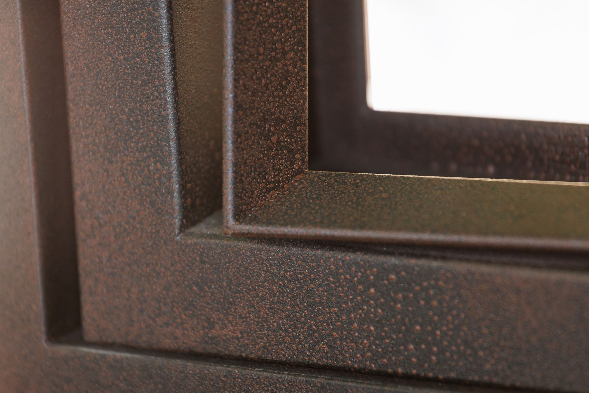 Un primo piano del telaio di una finestra marrone su uno sfondo bianco.