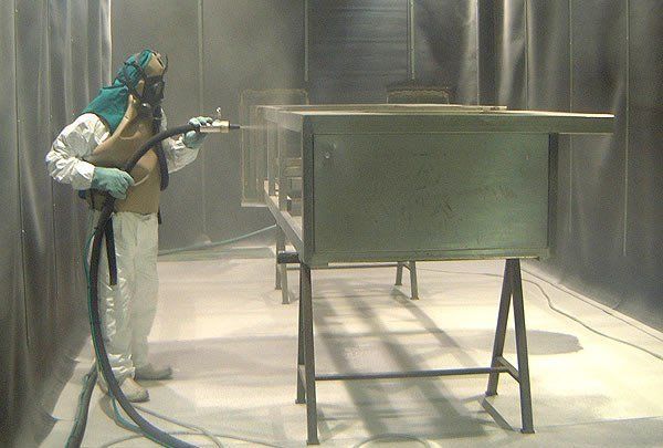 Una fila di recinzioni metalliche appese a un nastro trasportatore in una fabbrica