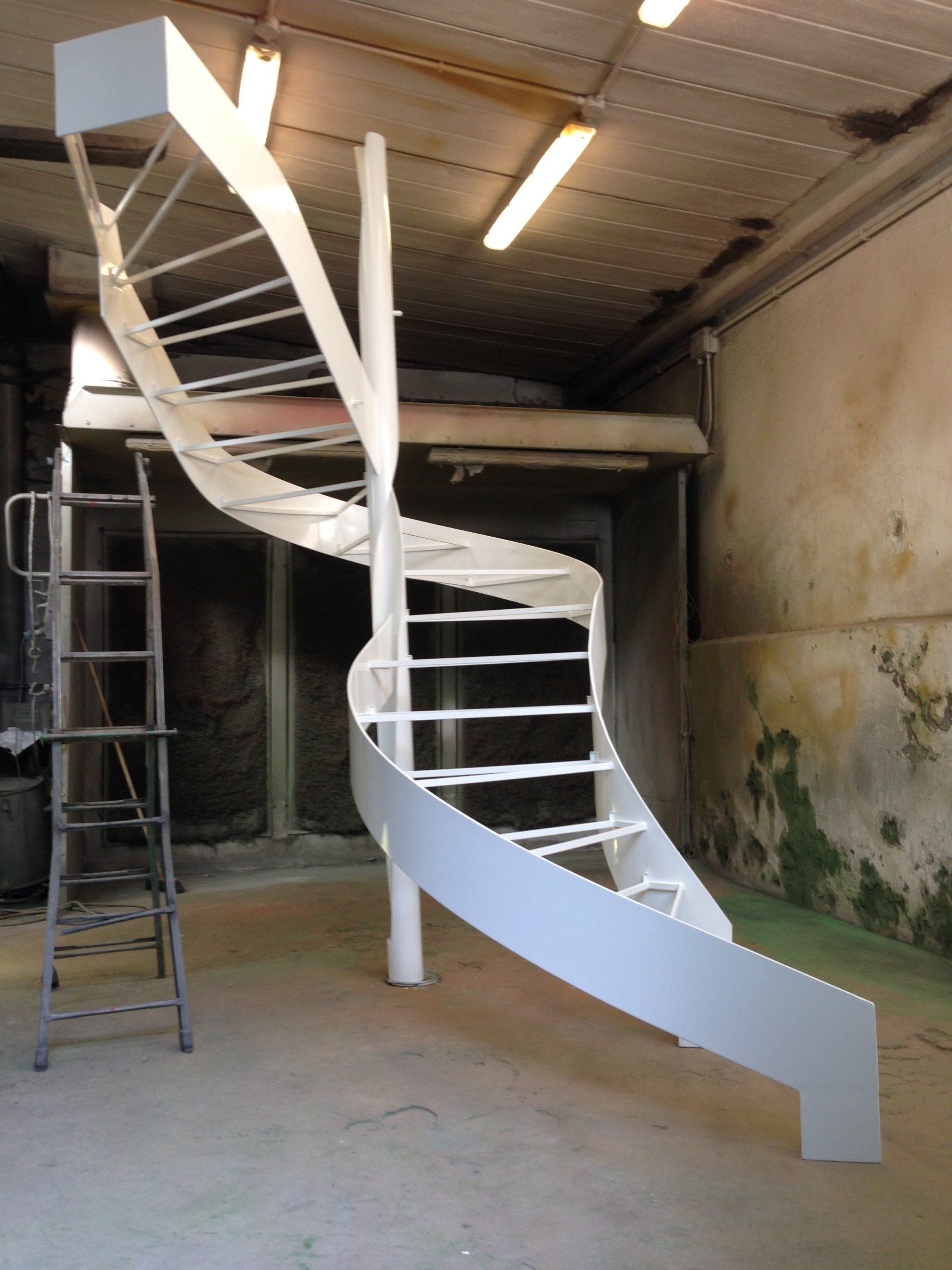 Una scala a chiocciola bianca in una stanza con una scala