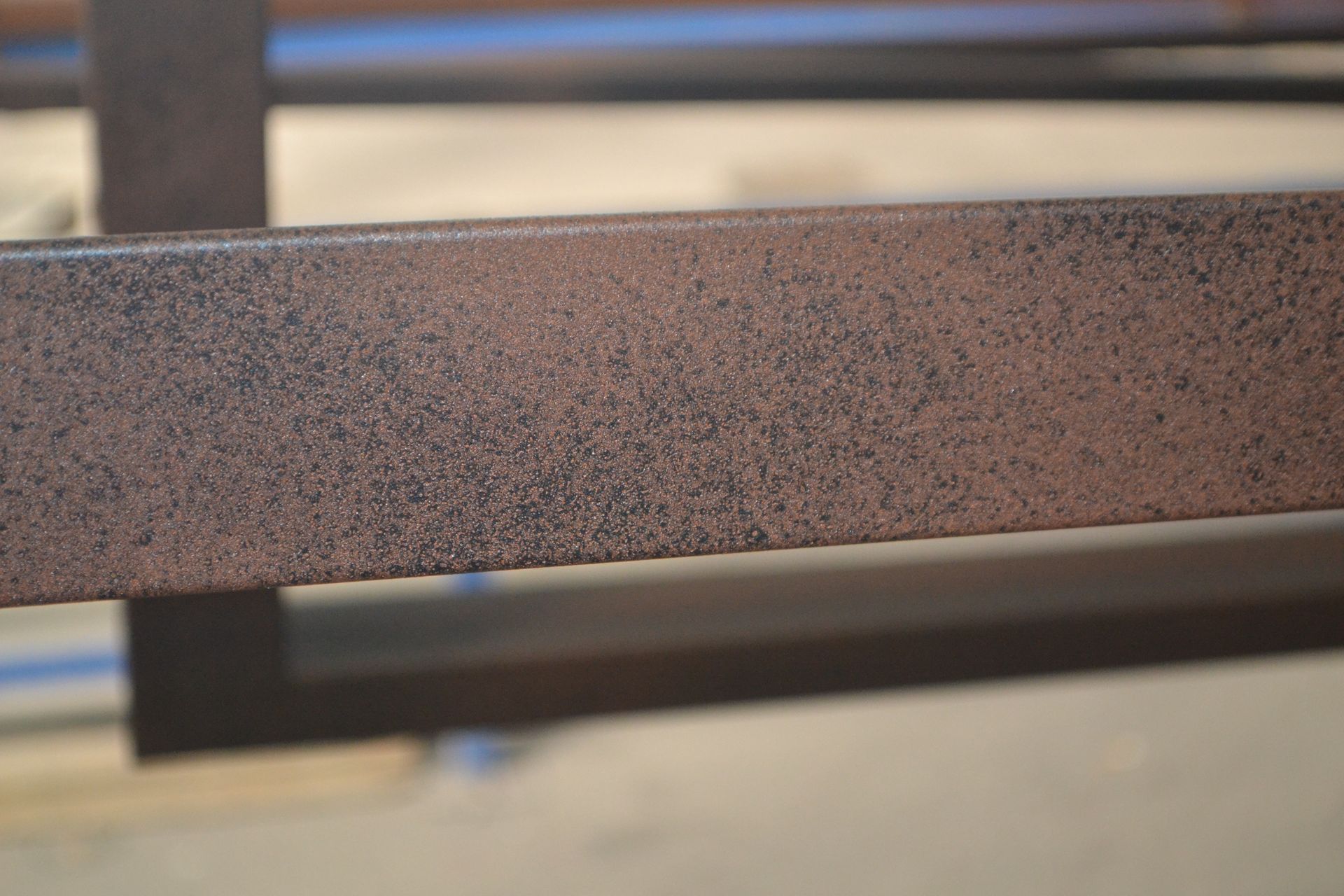 Primo piano di una barra di metallo arrugginita su un tavolo.