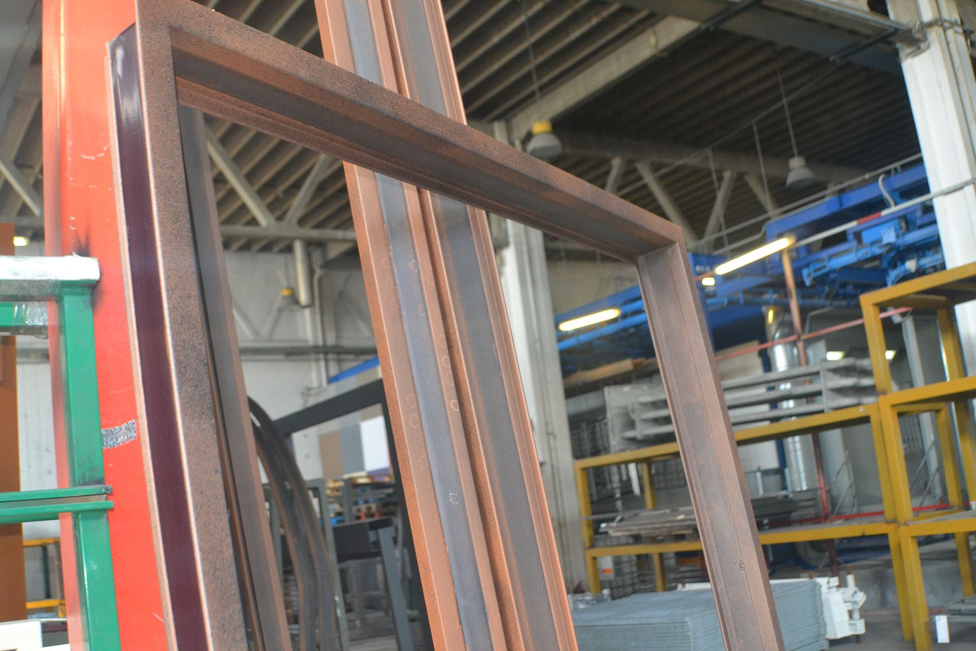 Un mucchio di telai metallici sono accatastati uno sopra l'altro in un magazzino.