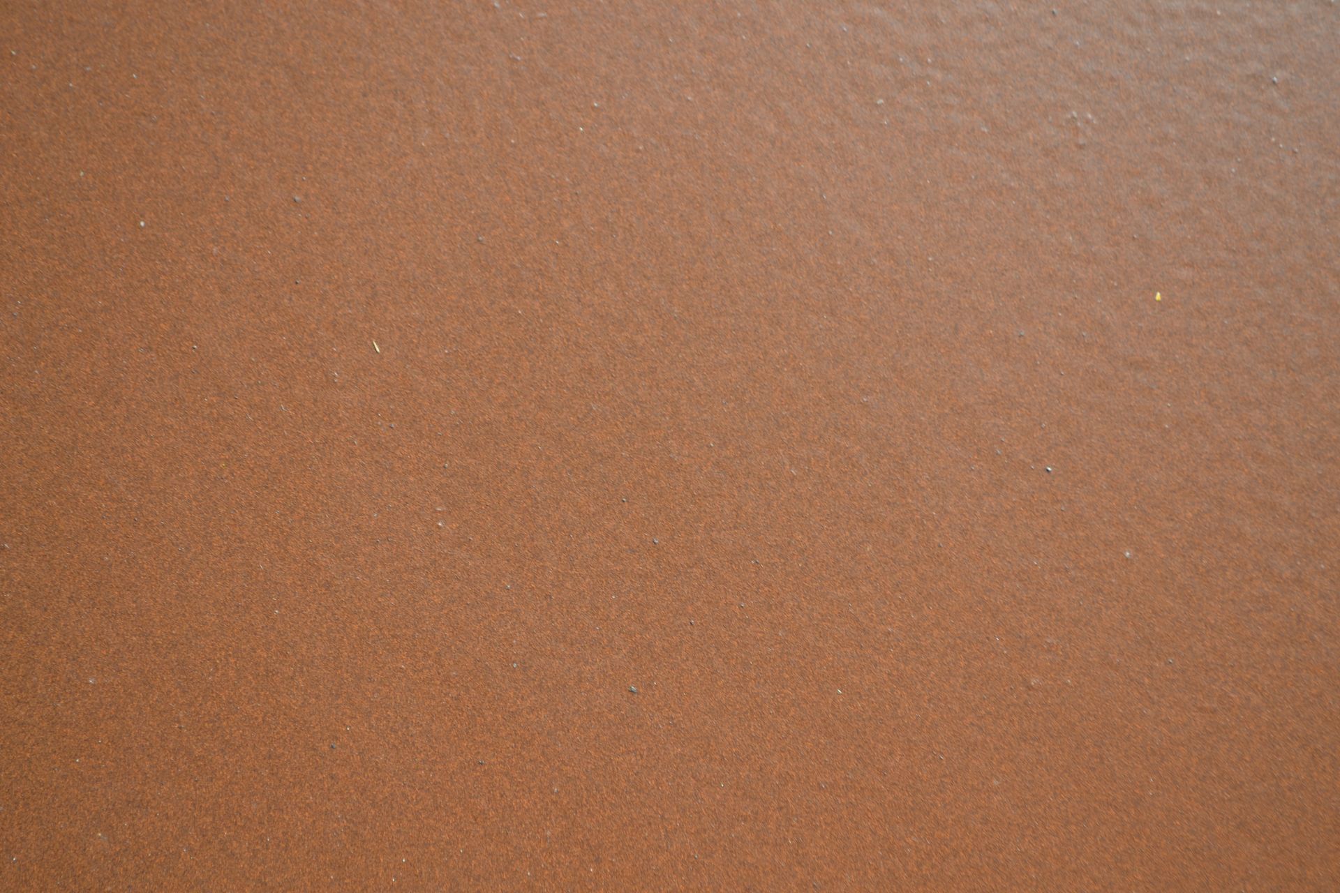 Primo piano di una superficie marrone con una consistenza granulosa.