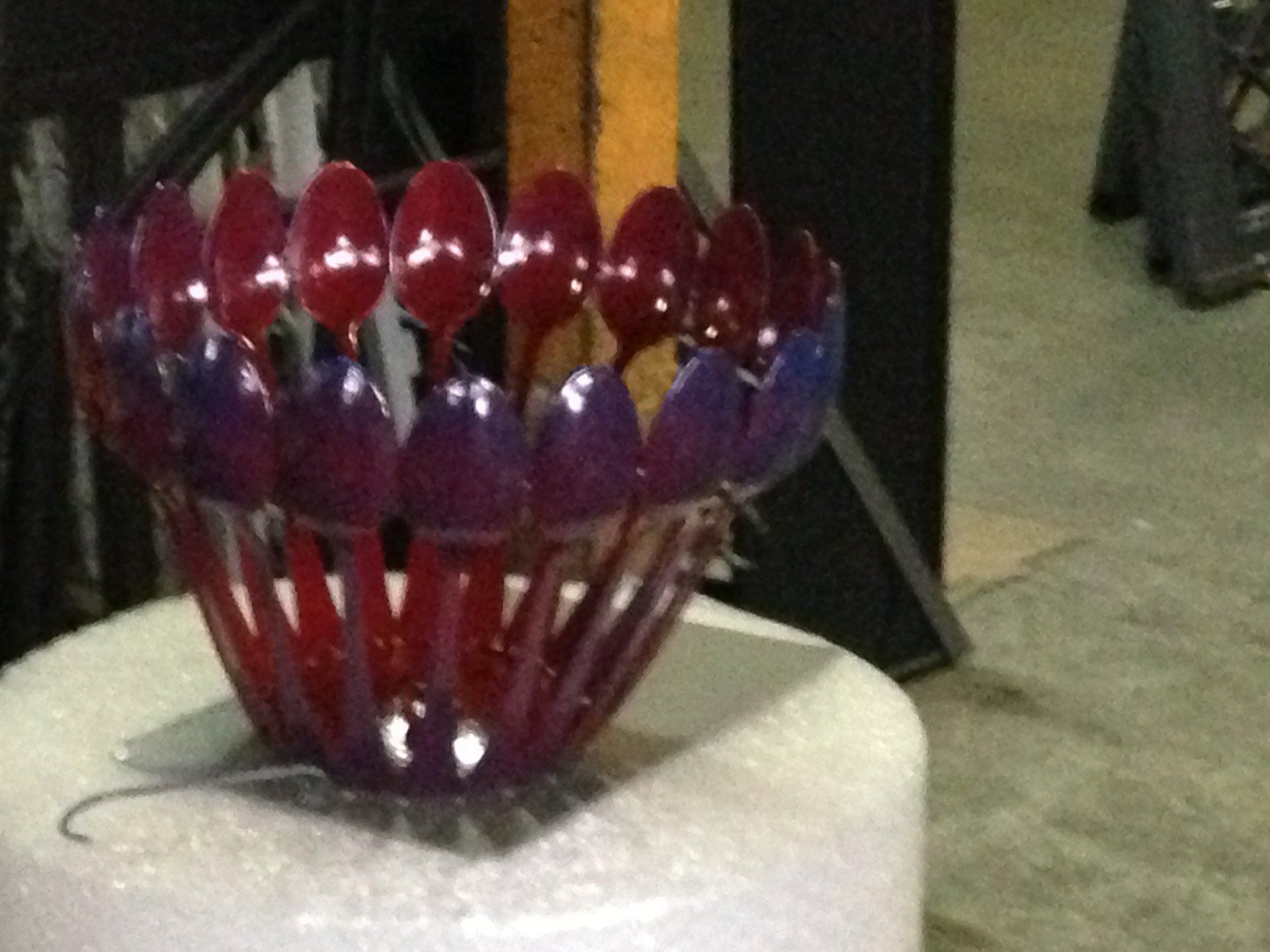 Una ciotola fatta di cucchiai di plastica è appoggiata su un tavolo