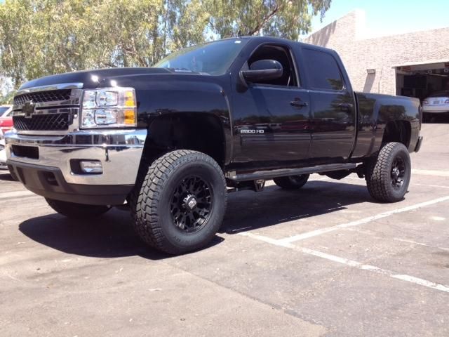 A black truck is parked in a parking lot.
