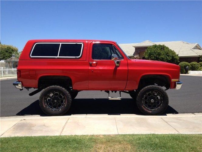 A red truck is parked on the side of the road
